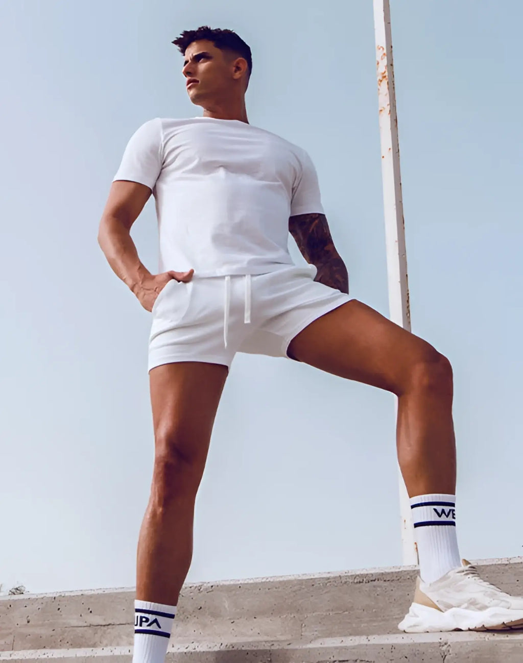 White athletic shorts with a drawstring waistband paired with supawear white crew neck t-shirt for casual wear