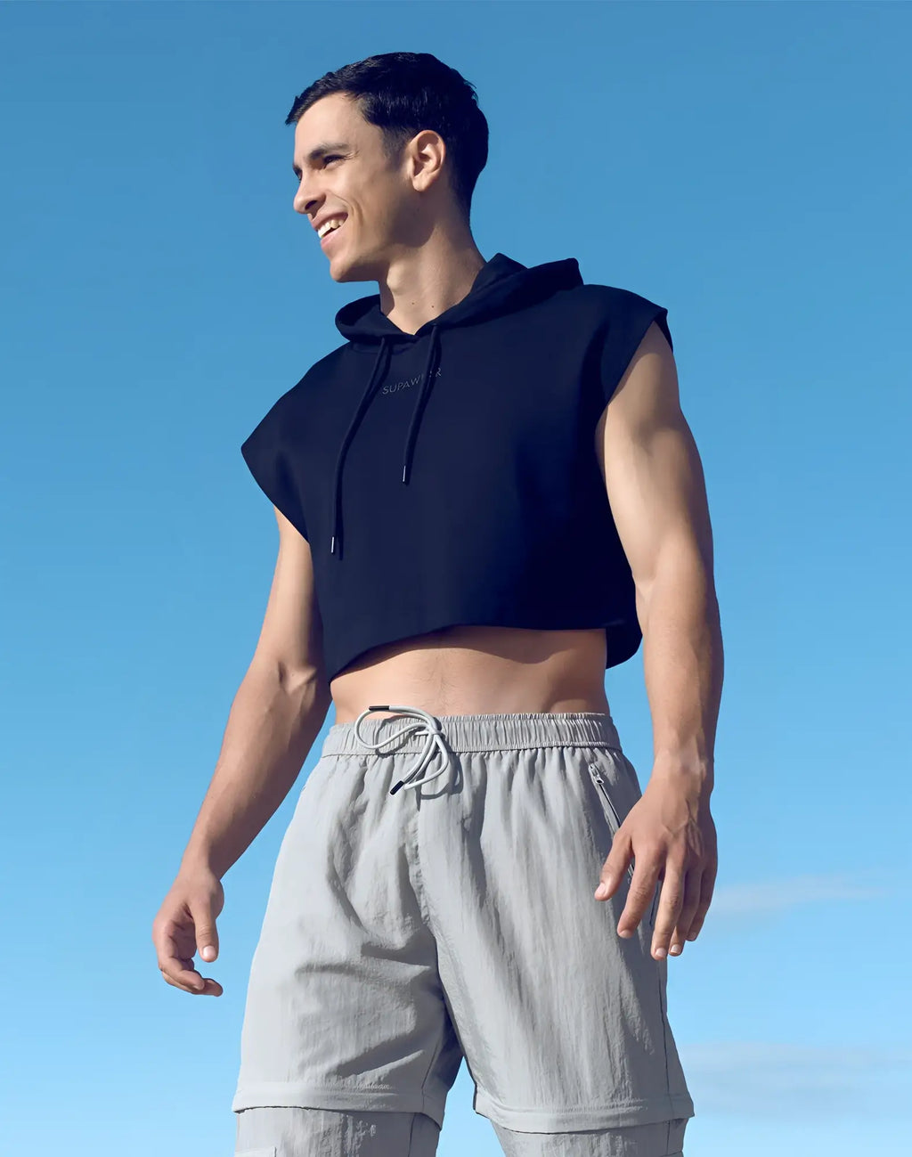 Black sleeveless cropped hoodie with drawstring hood and subtle front logo by SUPAWEAR for casual wear