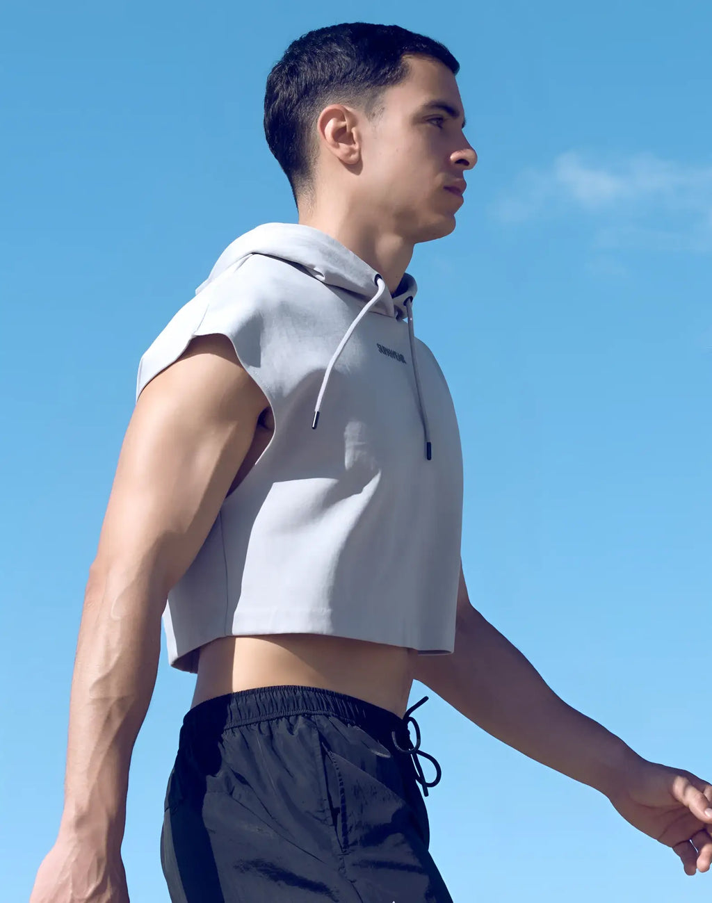 Light gray sleeveless cropped hoodie with drawstring hood and subtle front logo from SUPAWEAR in soft fabric