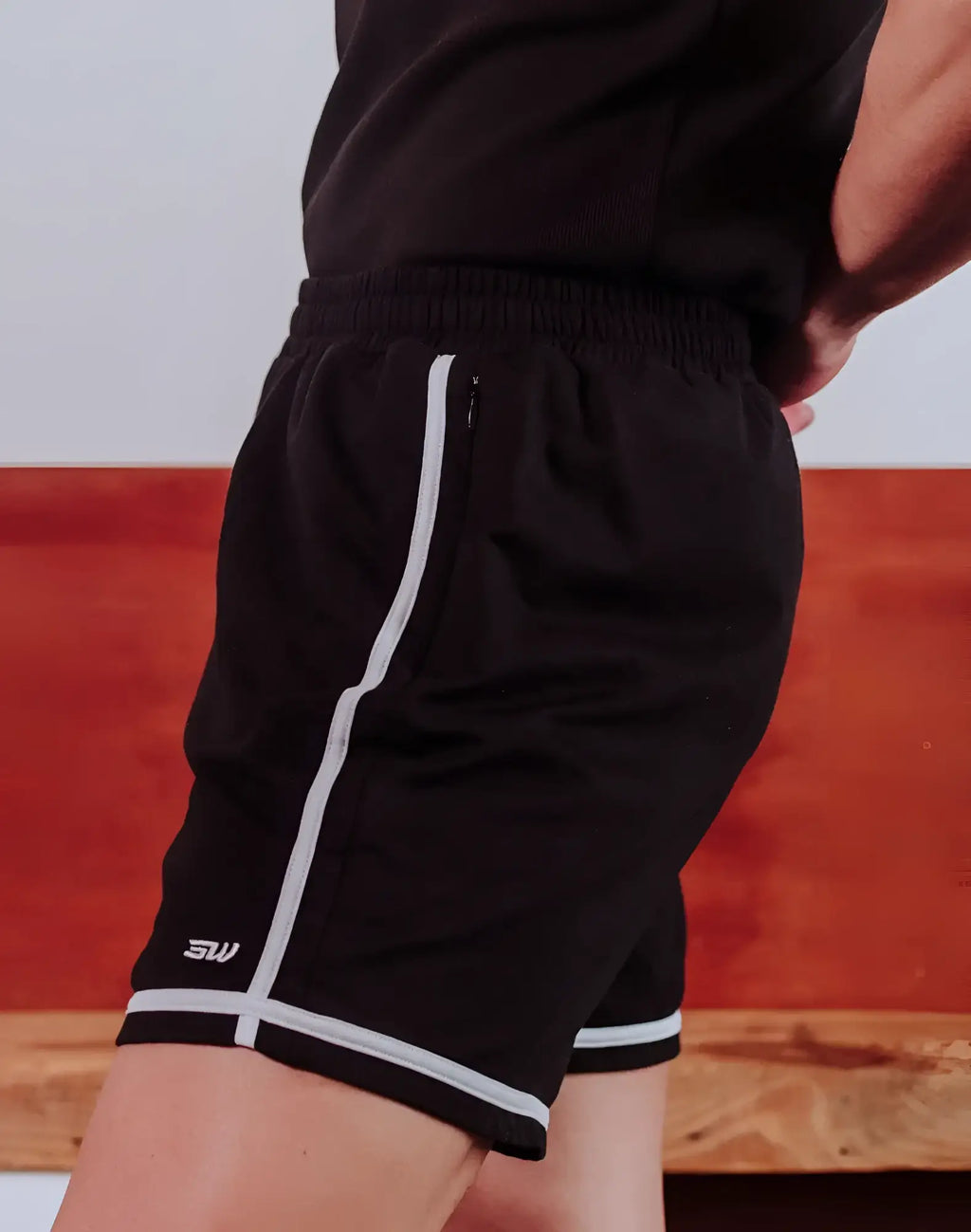 Black supawear crux athletic shorts with white side stripe and hem trim featuring logo on lower left leg