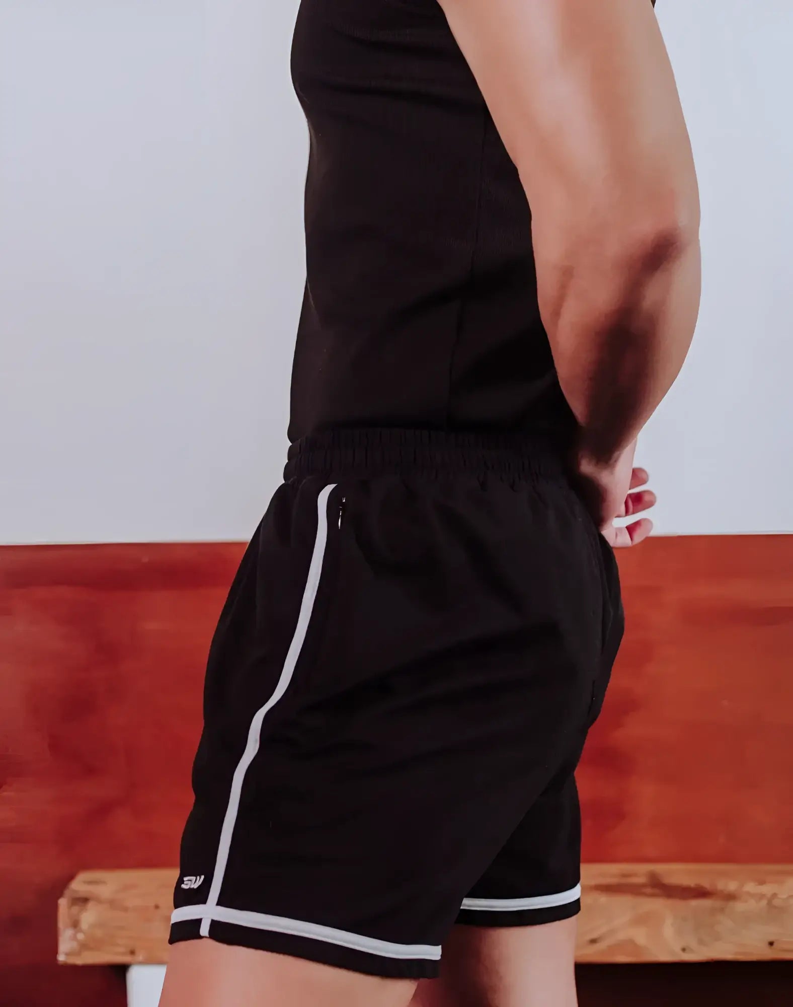 Black athletic shorts with white side stripes and trim, featuring a small logo on the lower left leg.