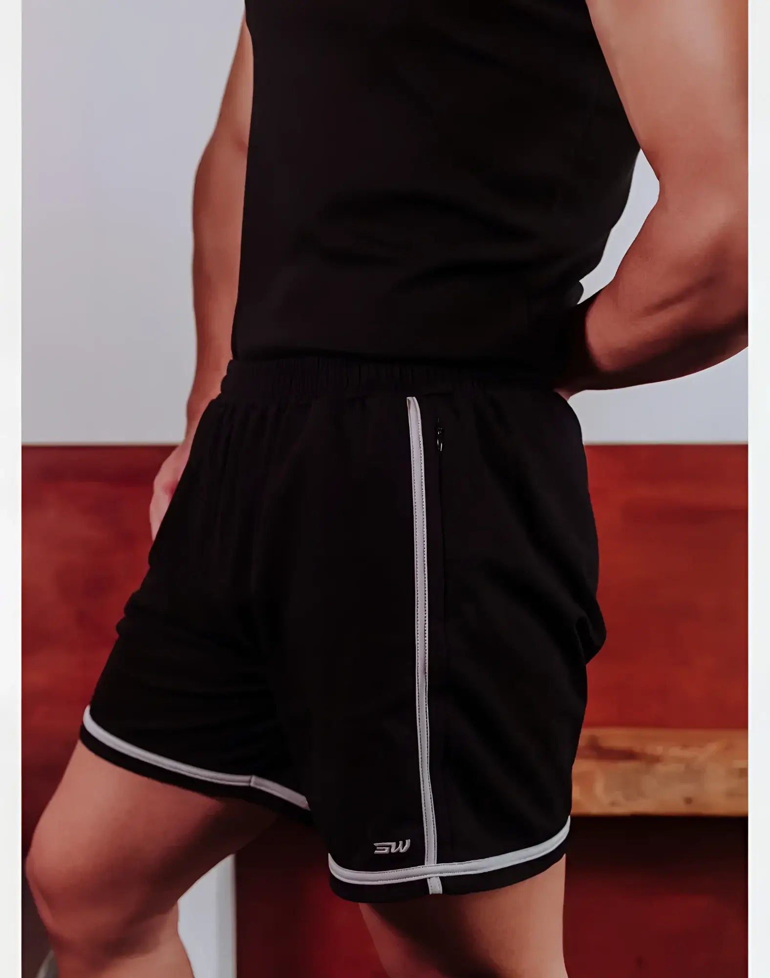 SupaWear Crux black athletic shorts with white side stripes and hem trim featuring a small sw logo on the lower left leg