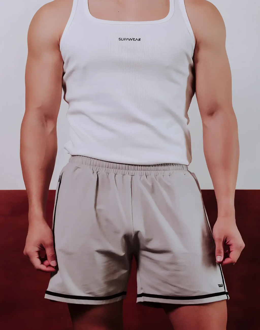 White ribbed tank top with supawear logo across the chest paired with grey supawear crux shorts