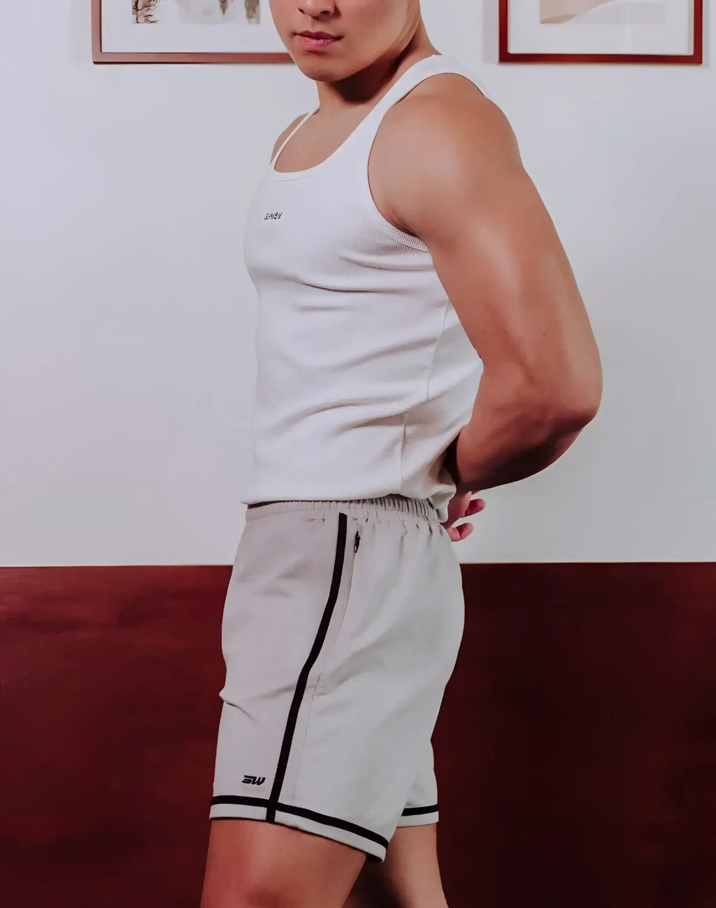 White ribbed tank top with small logo on chest paired with supawear crux grey shorts for casual wear