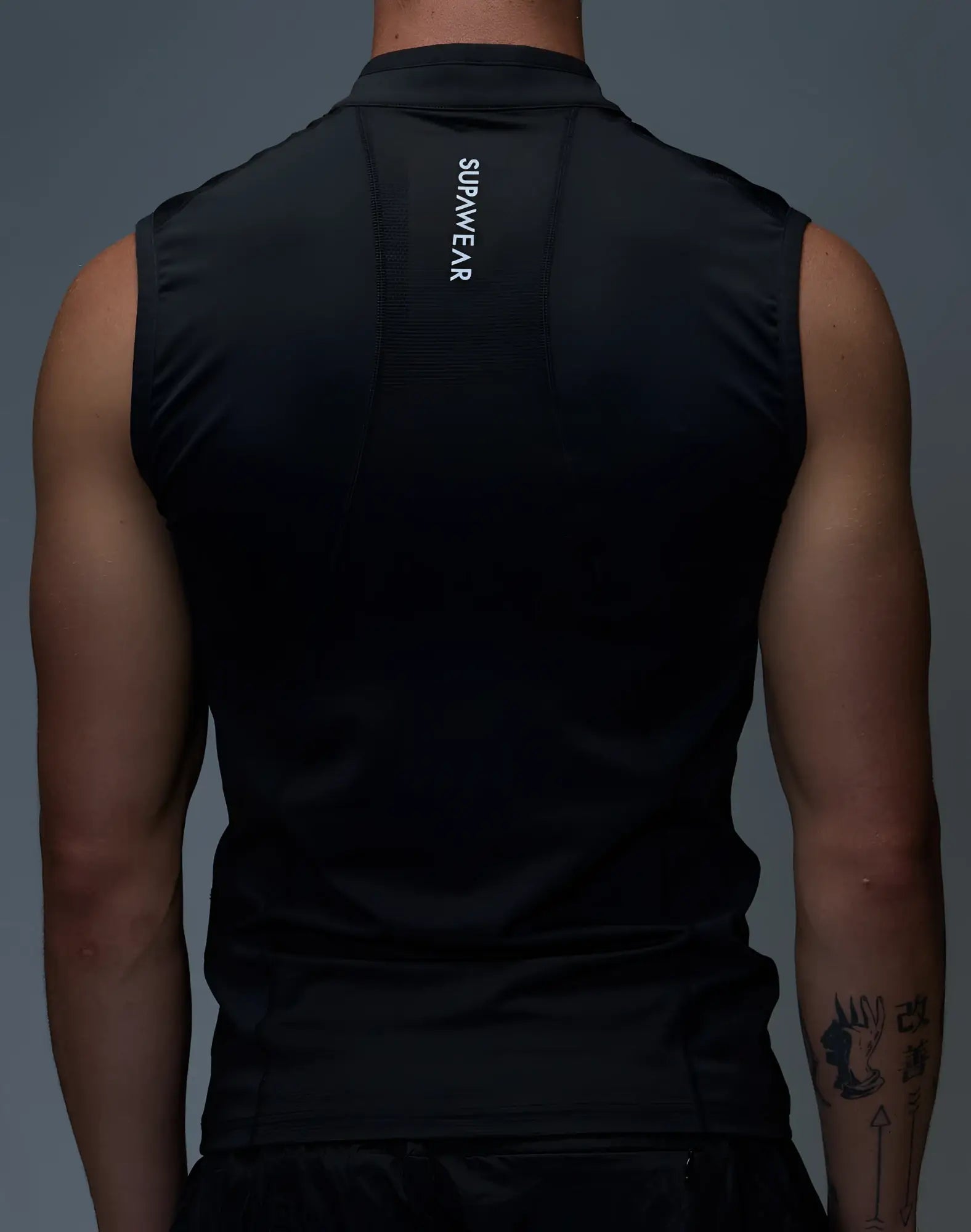 Back view of supawear gym2street black sleeveless half-zip vest with high collar and vertical supreme branding
