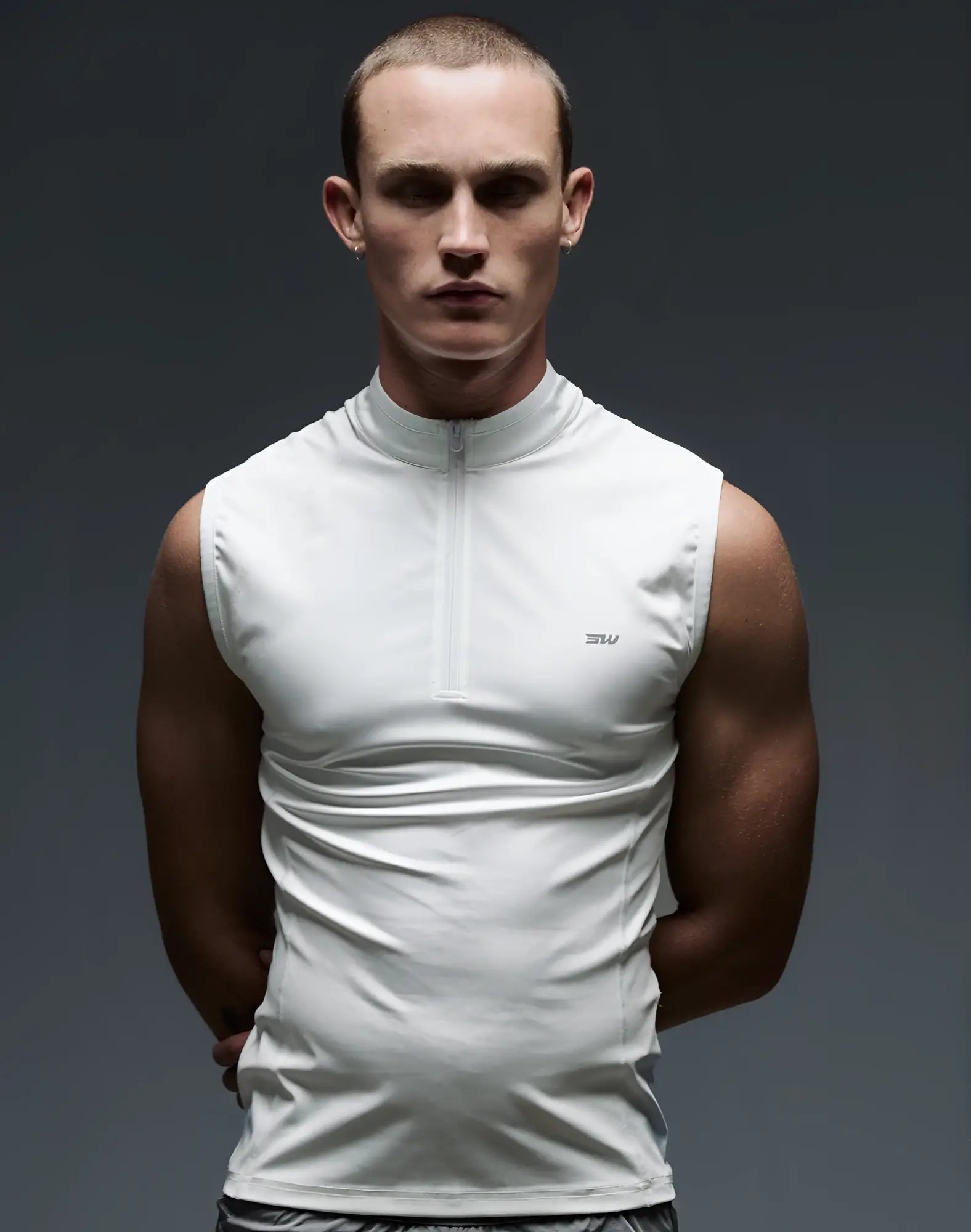 White sleeveless athletic half-zip top with subtle logo on chest from SUPAWEAR for gym and streetwear use