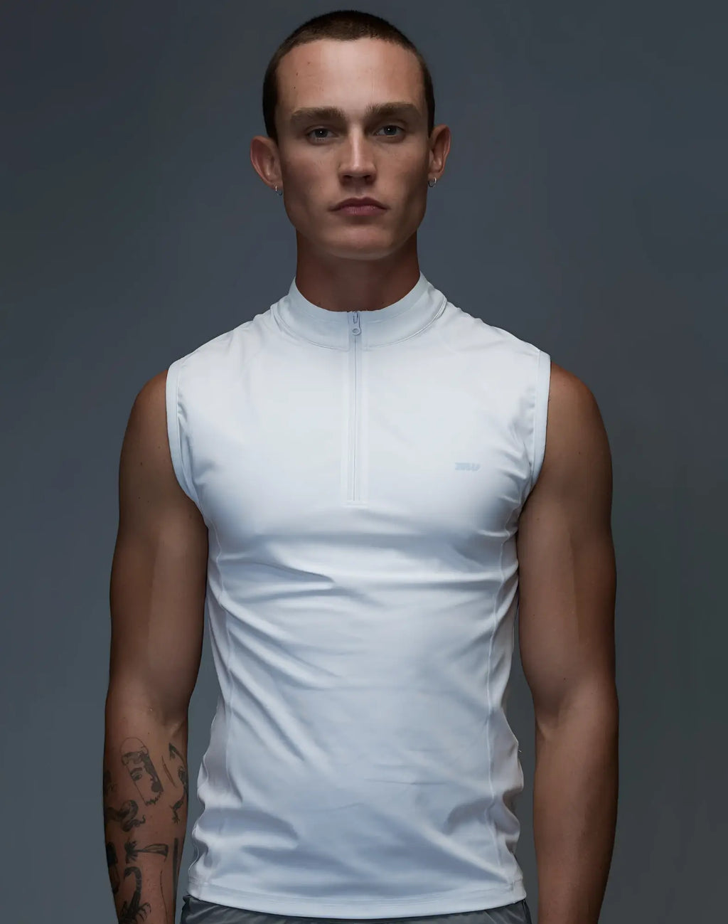 White sleeveless athletic top with half-zip neckline and subtle SUPAWEAR logo designed for gym and street use