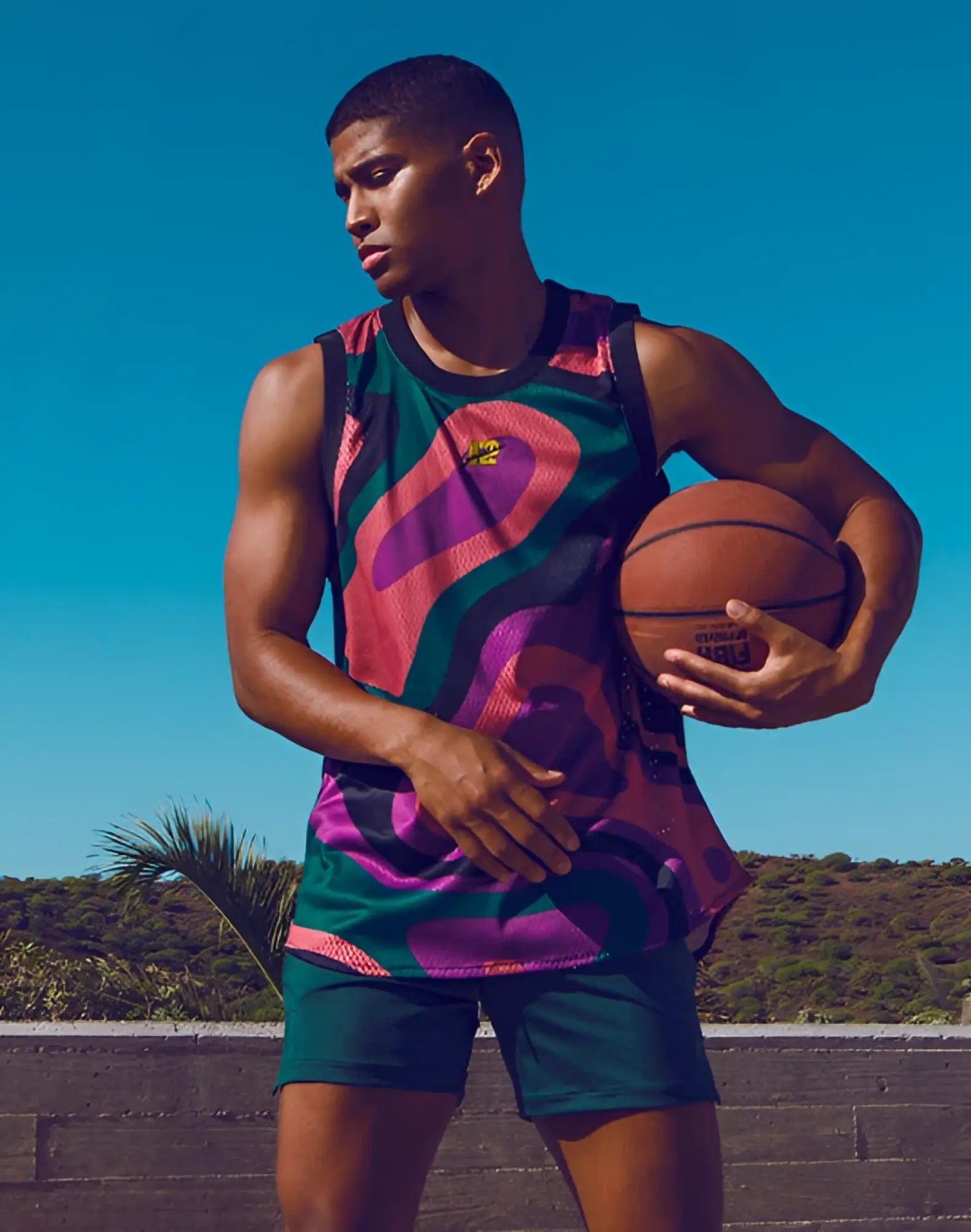 SupaWear mesh jersey tank top with vibrant multicolored mesh and bold pink and purple swirls on green base