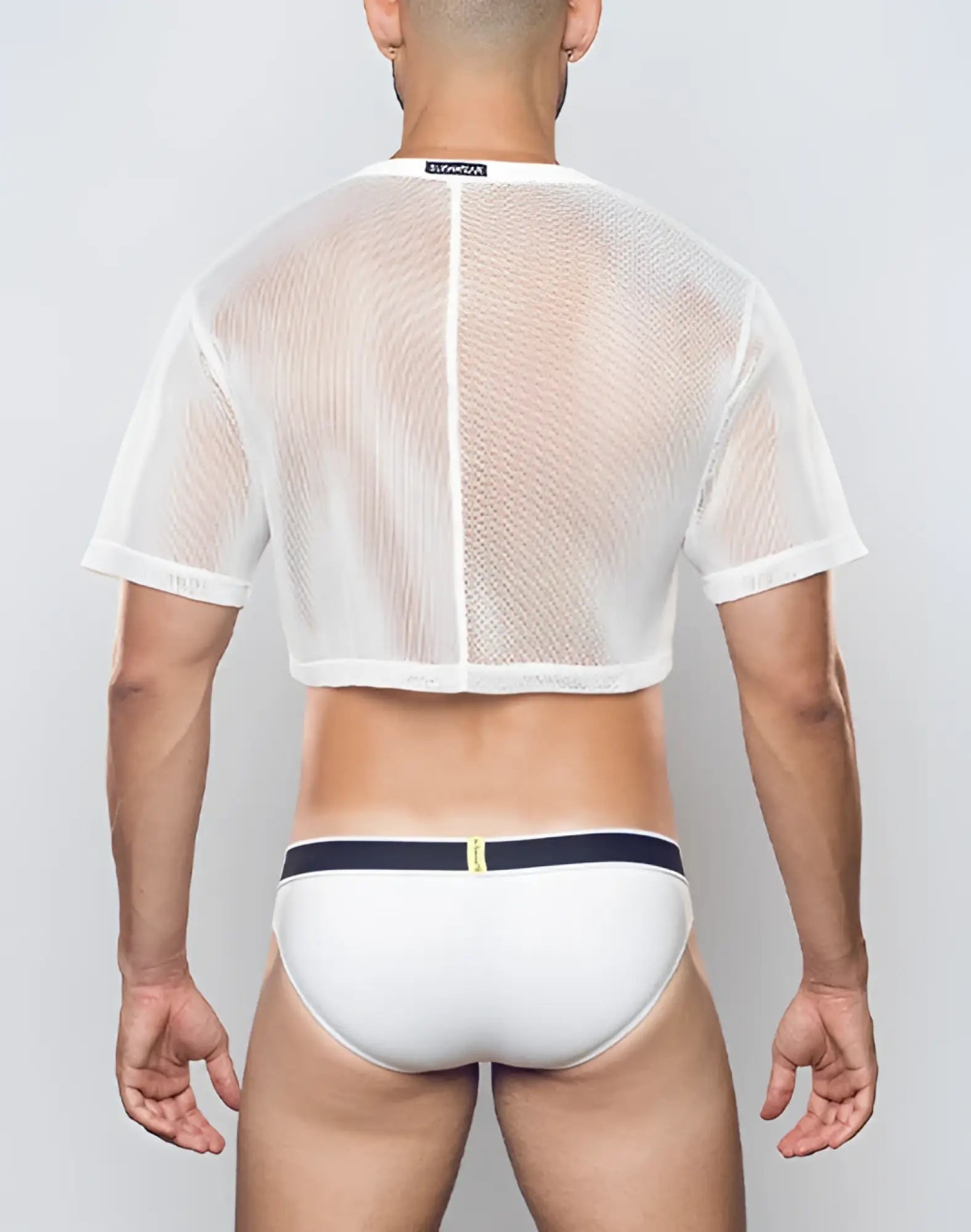 White mesh cropped tee with short sleeves and central zipper paired with white briefs with navy blue waistband by Supawear