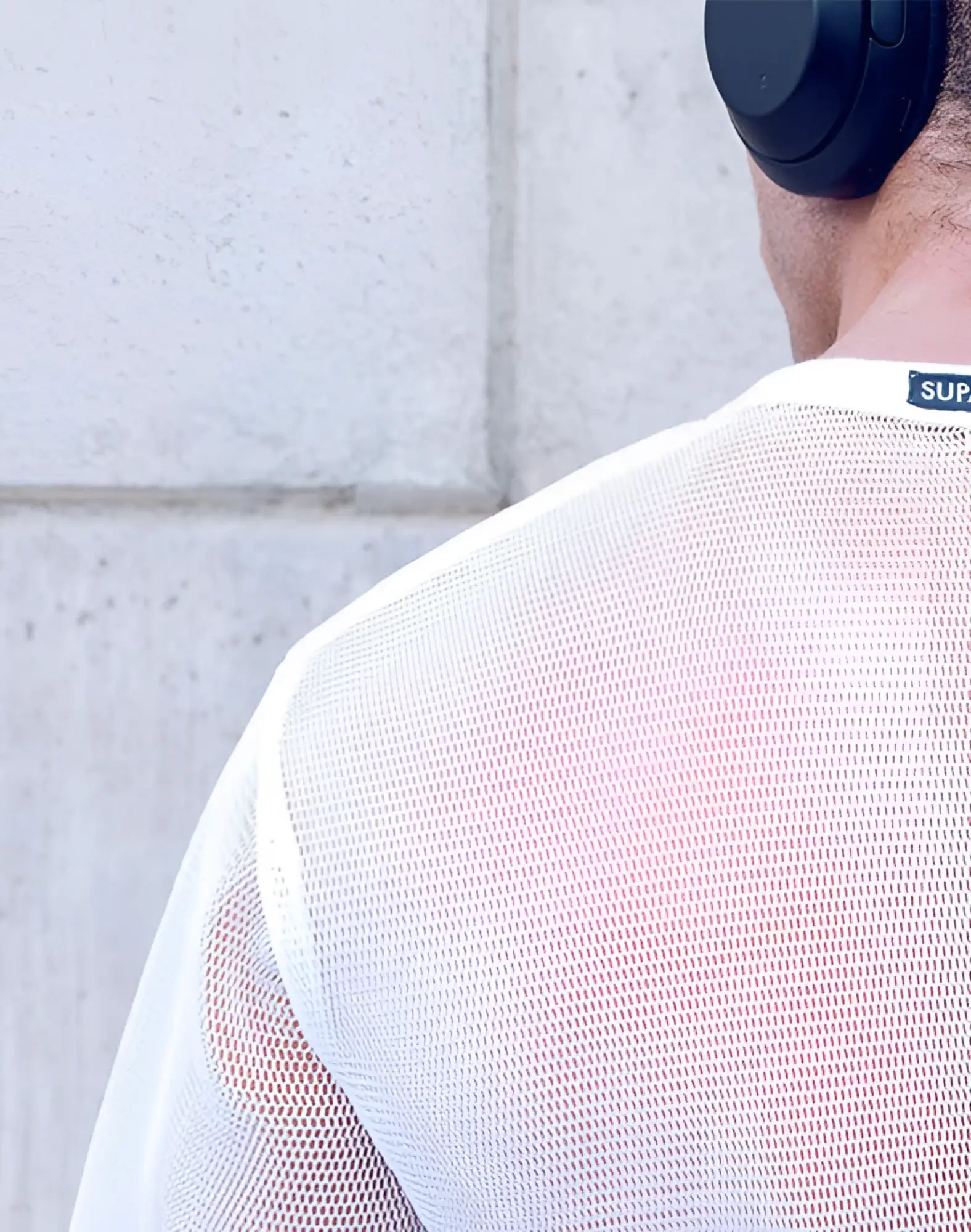 SupaWear mesh oversized cropped tee in white with a subtle textured pattern and a small black sup logo tag at neckline