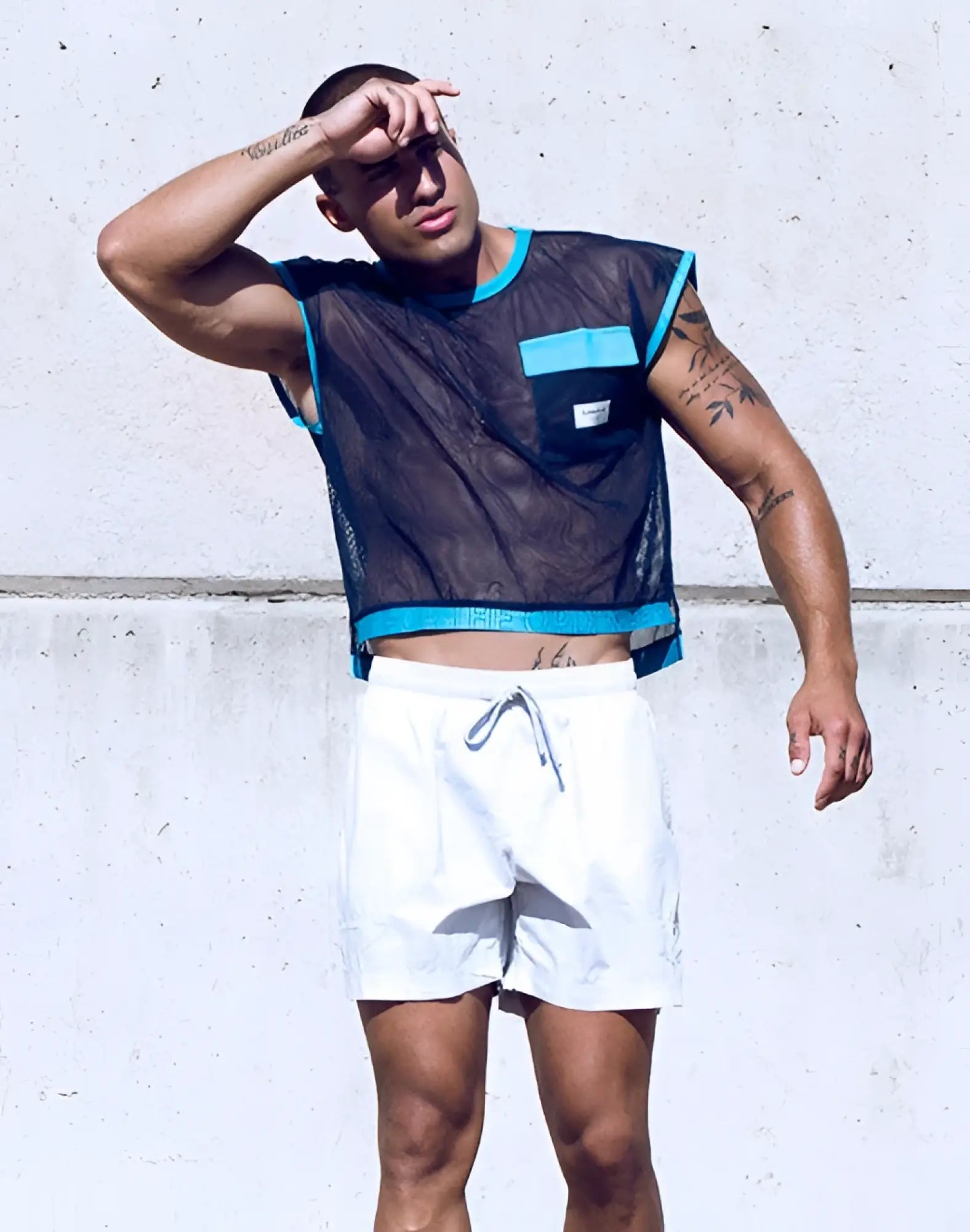 SupaWear neon mesh top navy blue black sleeveless with turquoise trim and pocket worn over white drawstring shorts