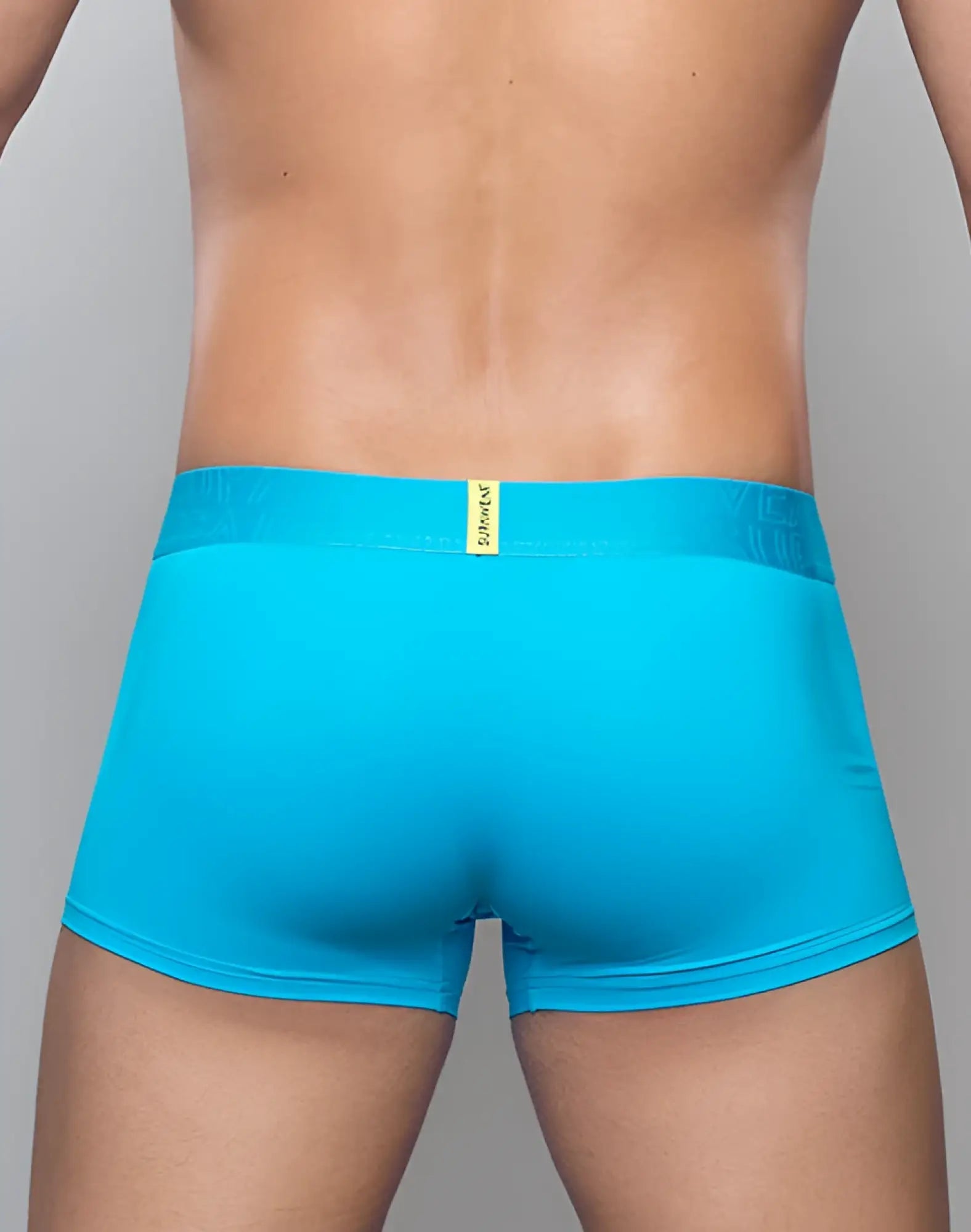 Bright turquoise SUPAWEAR neon trunk underwear with matching waistband and small yellow brand tag