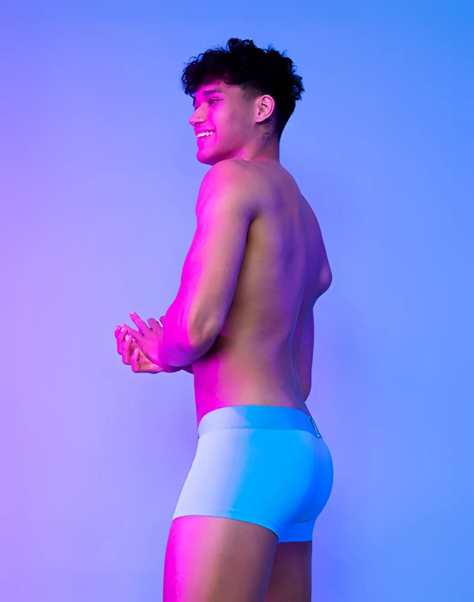 The man is wearing supawear neon trunk underwear in neon blue with a light blue seamless, form-fitting design