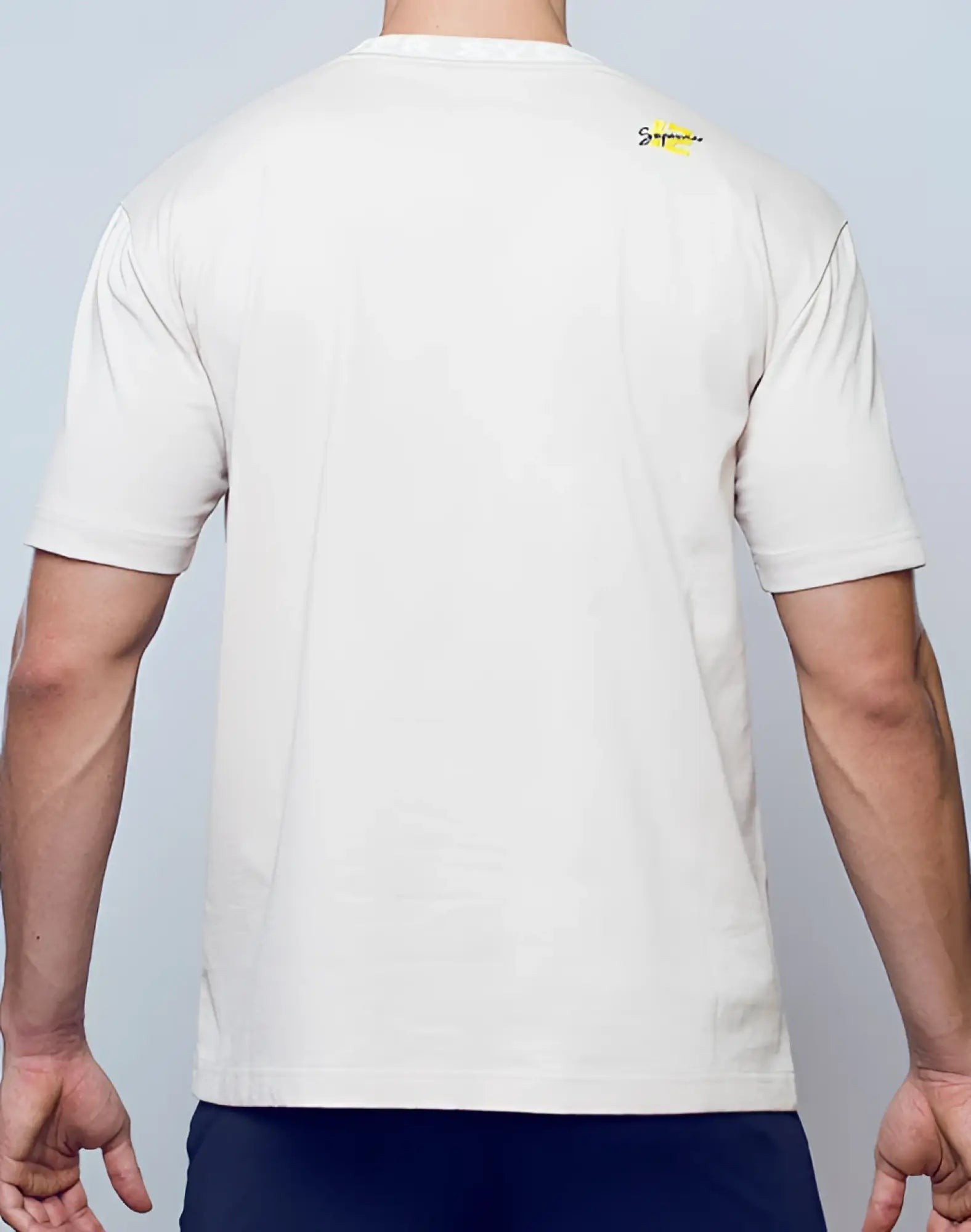 Off-white cotton supawear oversized tee moon beam beige with small yellow supreme logo on the upper back view