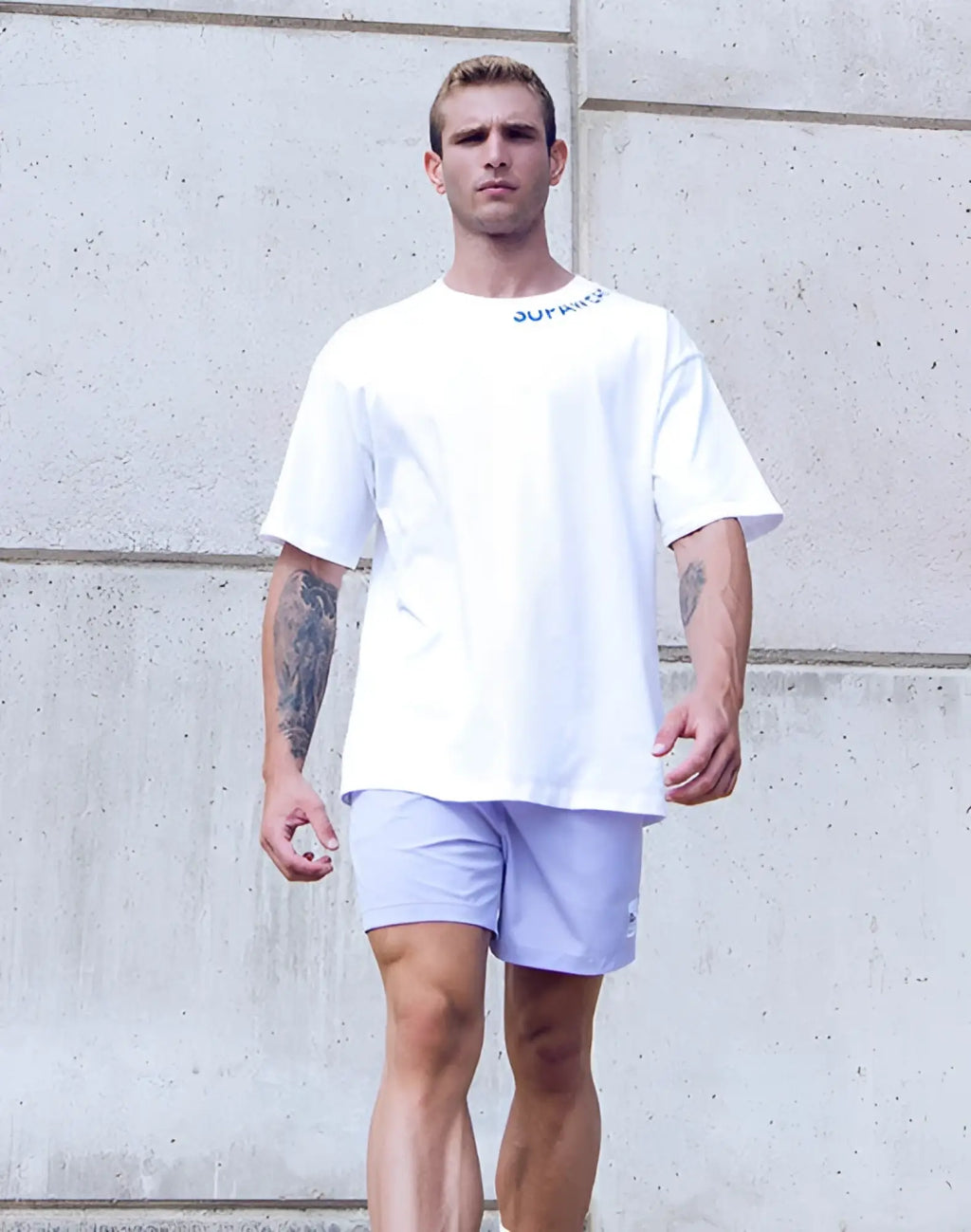 White oversized cotton tee from SUPAWEAR with blue supreme logo lettering across the neckline for casual wear