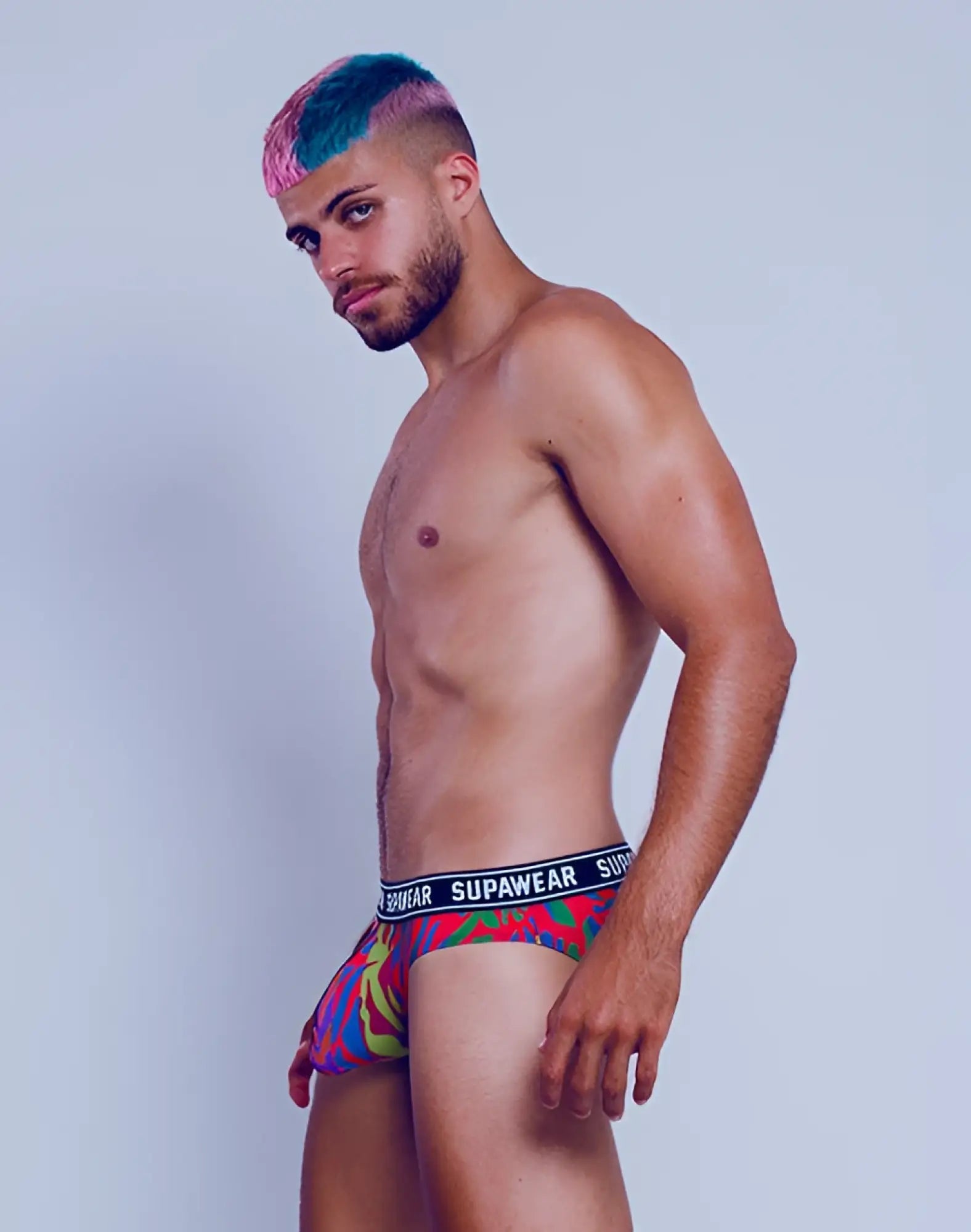Vibrant multicolored patterned supawear pow brief underwear with bold blue waistband featuring brand name crimson beast