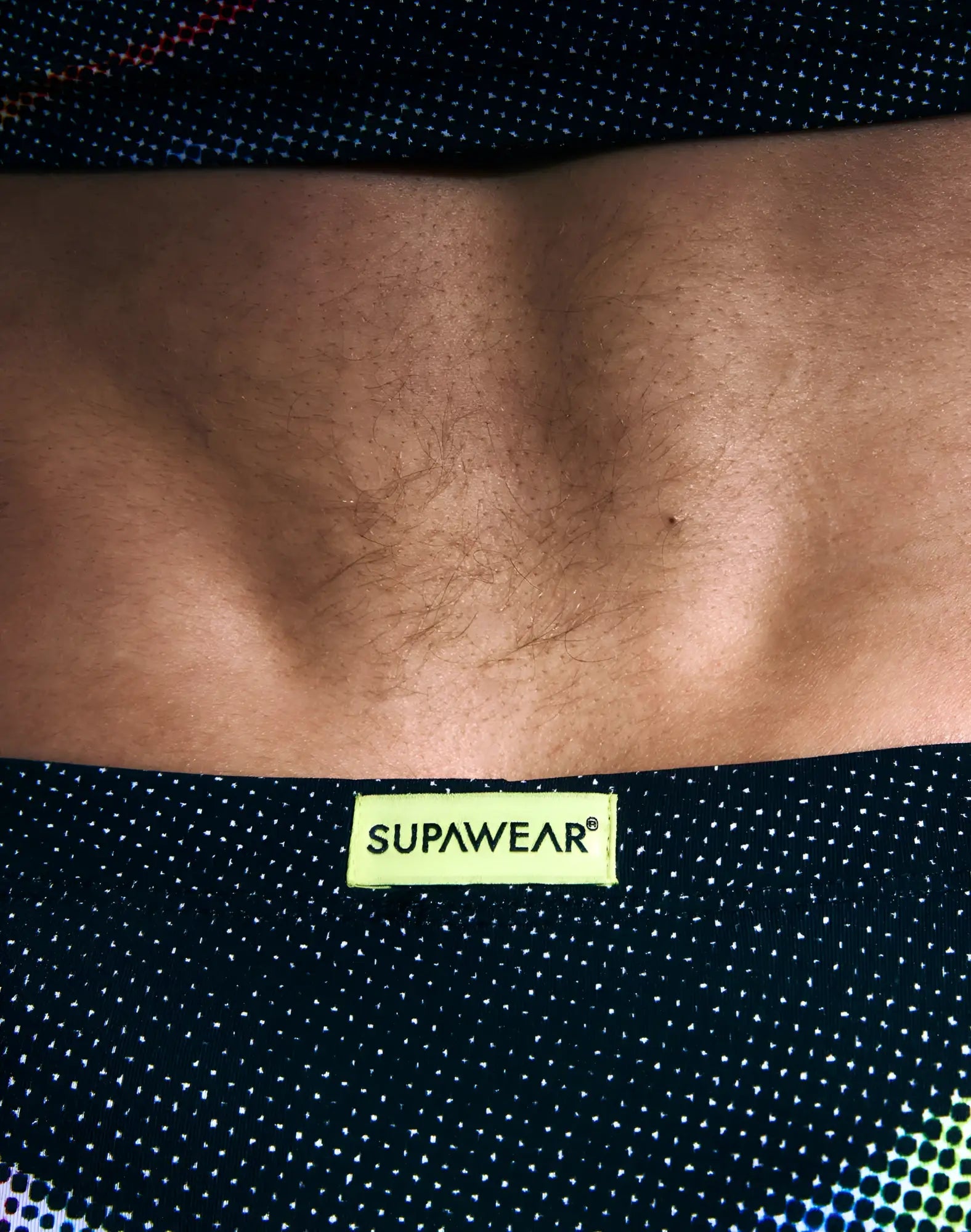 Black supawear printed pride brief underwear waistband with polka dots and a bright yellow label visible