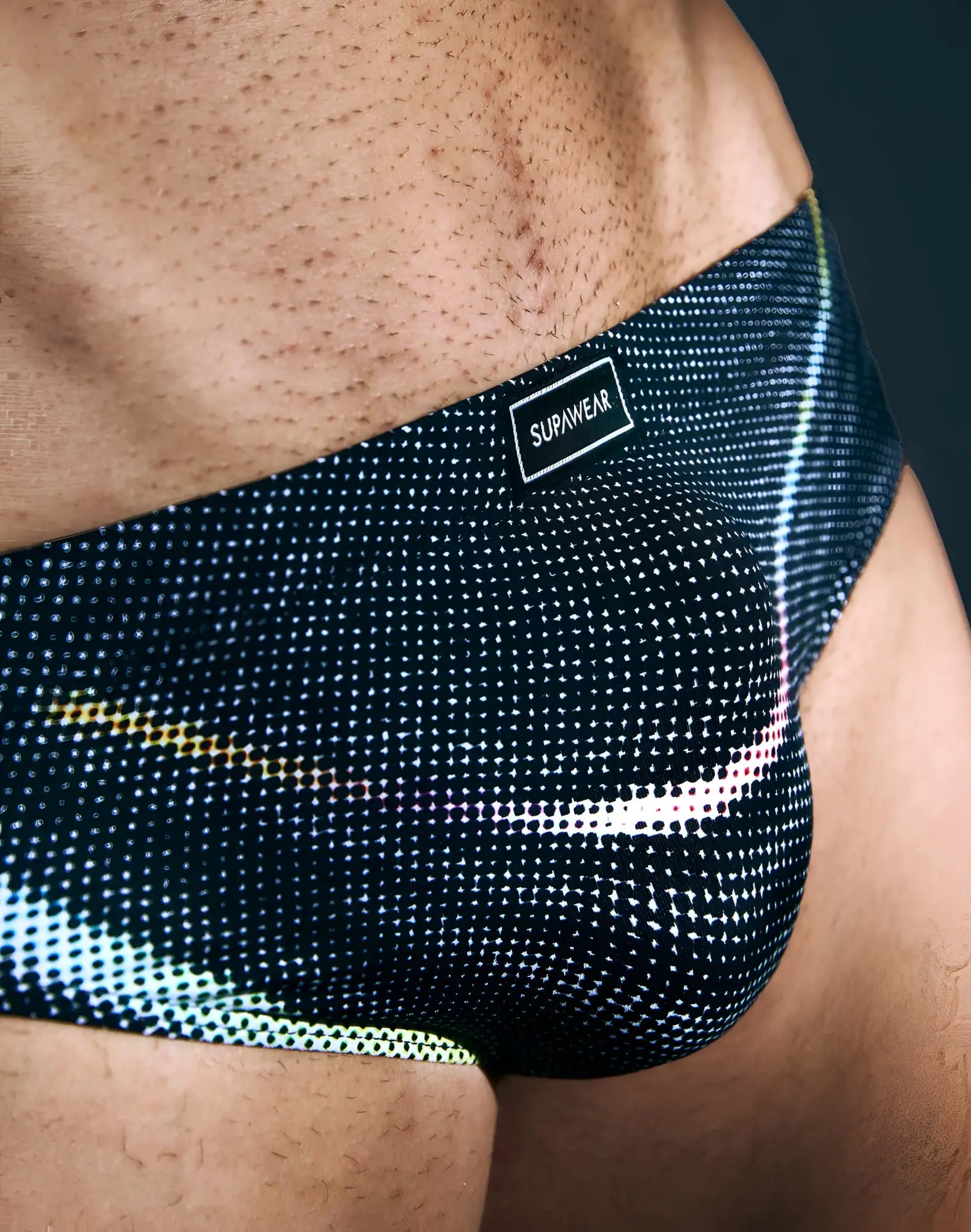 Black supawear printed pride brief underwear featuring neon diagonal stripes and a halftone dot pattern