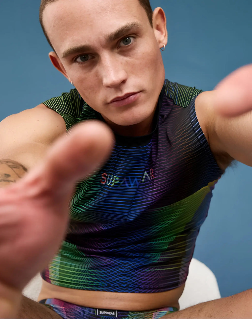 A vibrant supawear printed pride crop tank featuring a rainbow gradient and colorful brand lettering across the chest