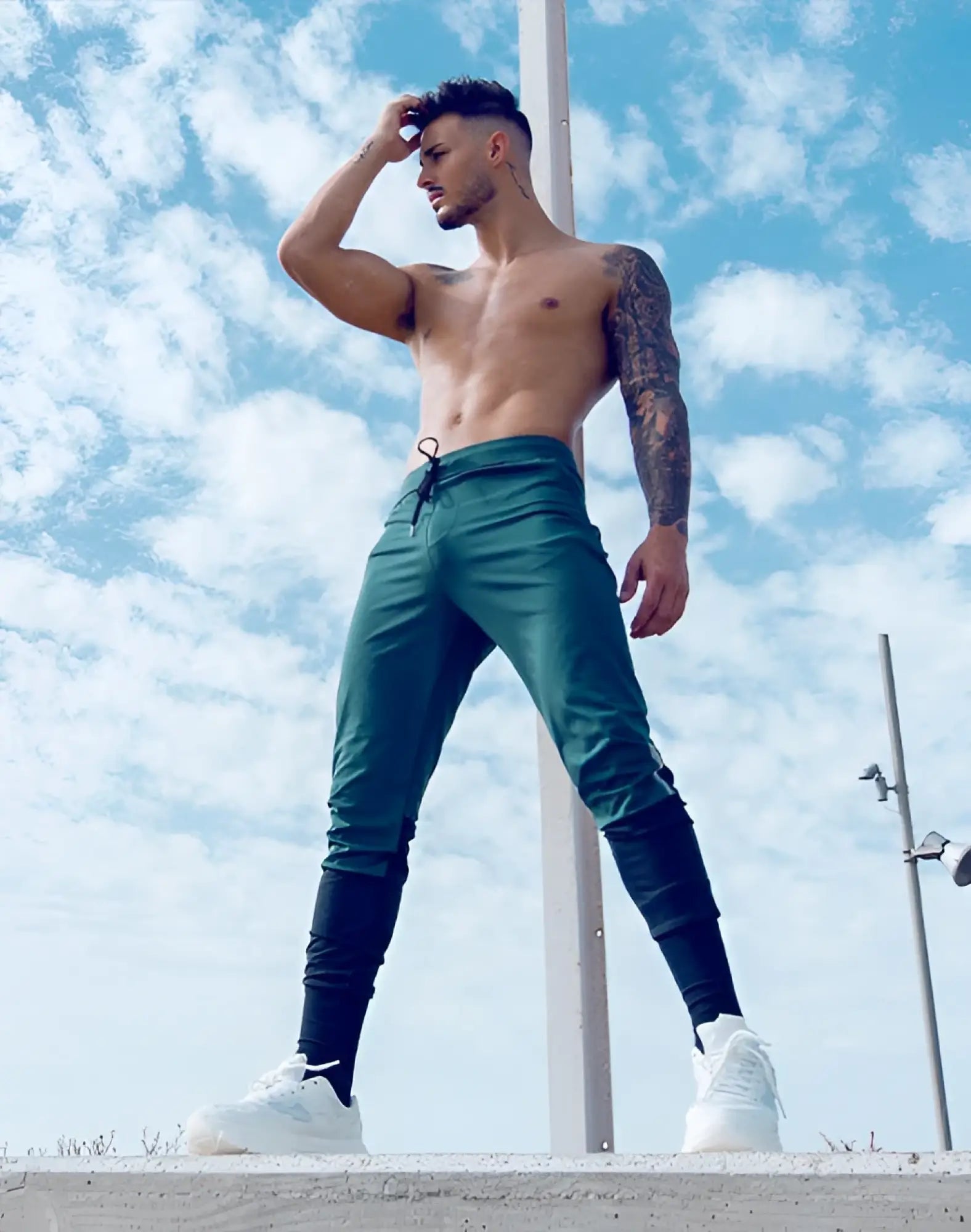 Green supawear pro-training pants with black leggings underneath and white sneakers for athletic use