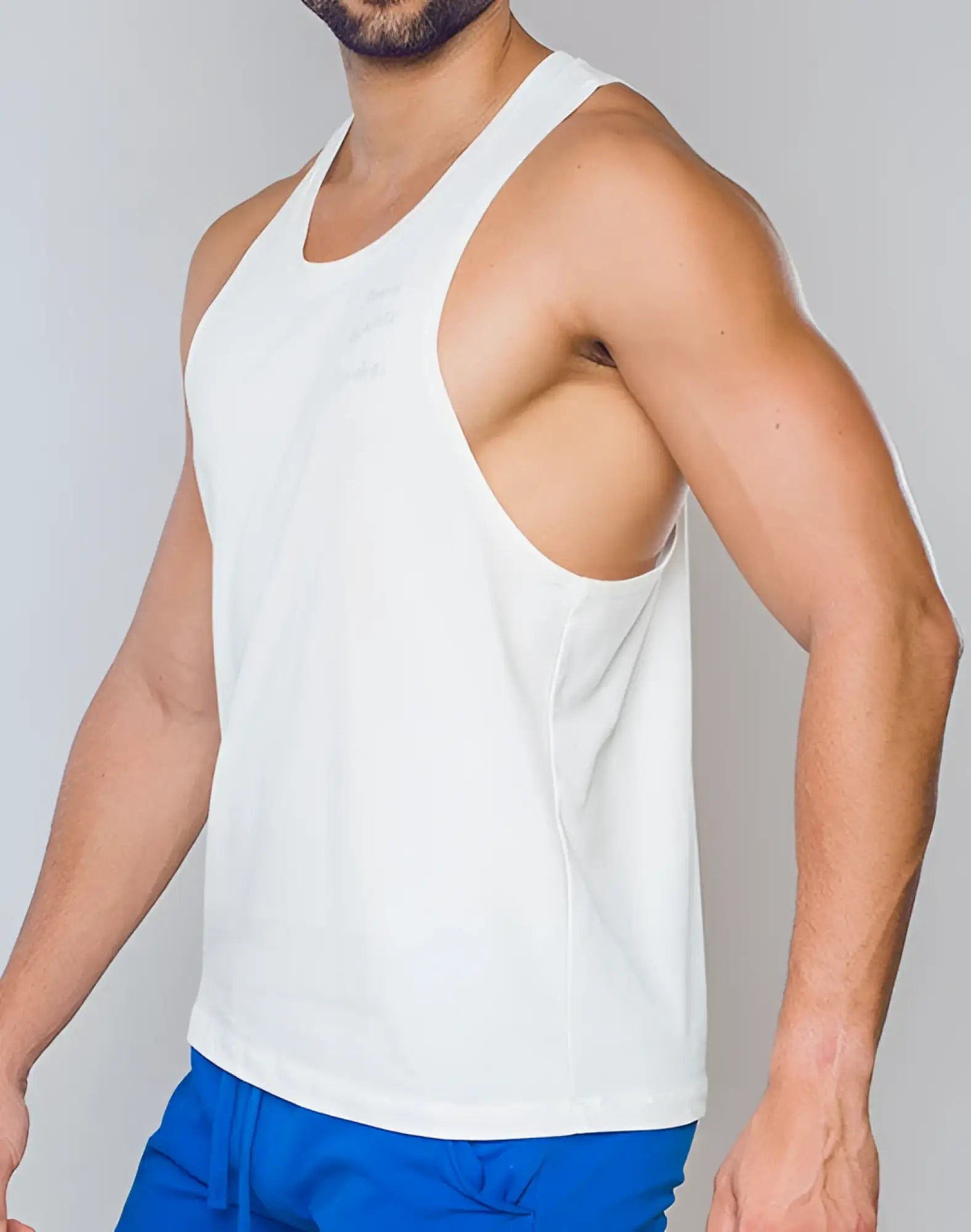 SupaWear white sleeveless athletic racer back singlet with subtle embroidered logo on chest perfect for workouts