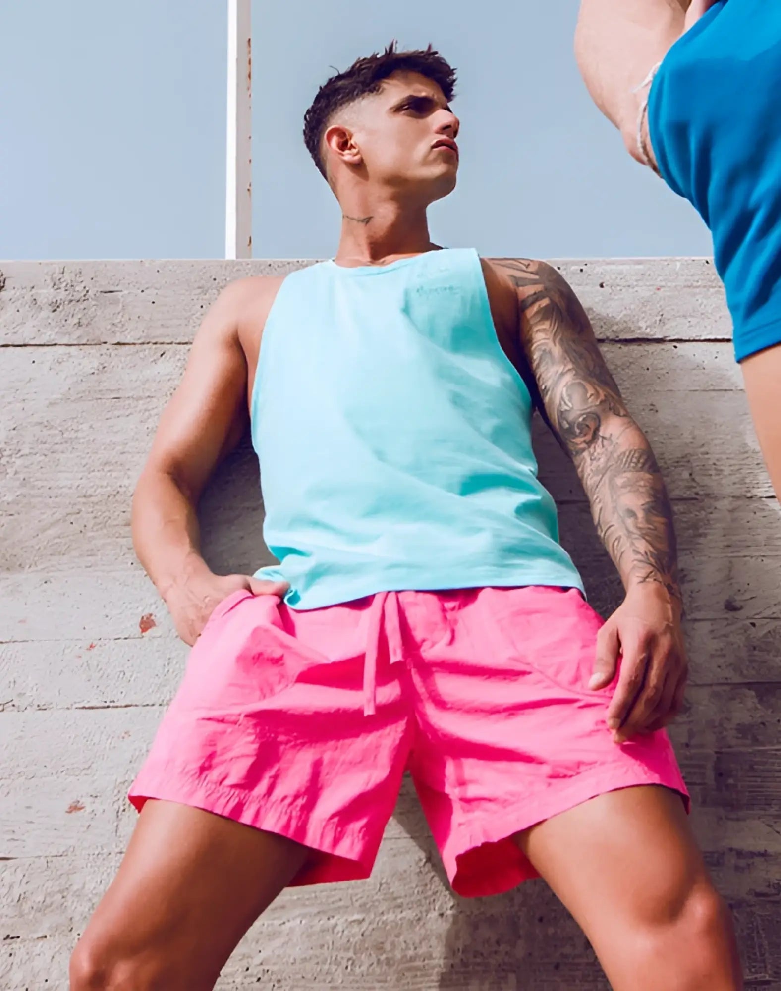 Bright pink shorts with a drawstring waistband paired with a supawear racer back singlet in turquoise blue