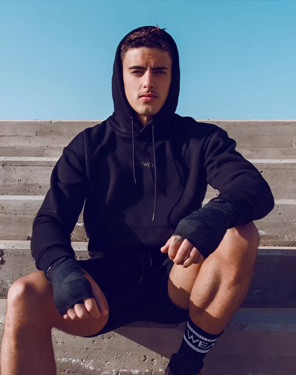 Black SUPAWEAR recovery hoodie with white chest lettering and matching black drawstrings in soft cotton blend material