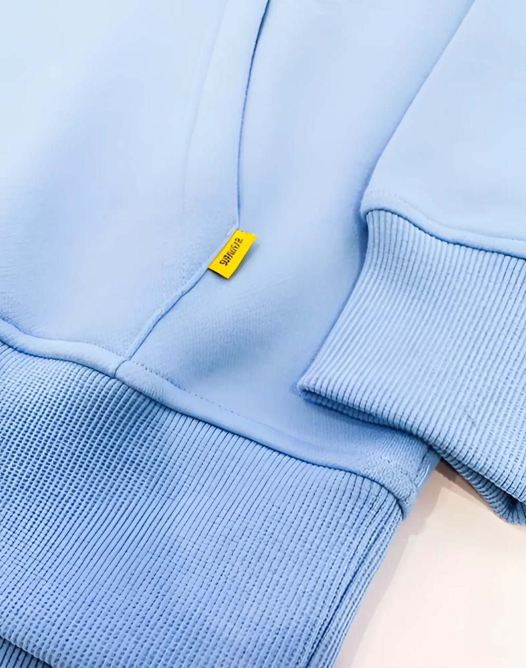 Light blue ribbed knit supawear recovery hoodie with small yellow brand tag on the chest in reboot blue color