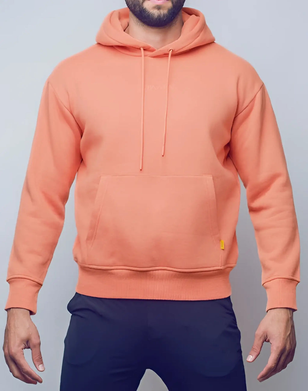 A soft peach-colored SUPAWEAR recovery hoodie with front pocket and matching drawstrings in reboot clay color