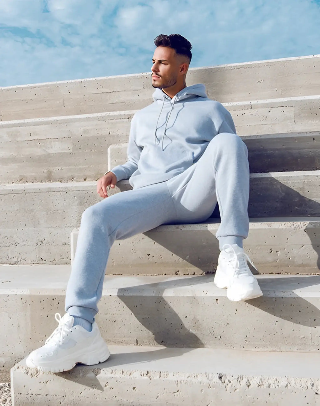 Light blue cotton hoodie with matching sweatpants and white chunky sneakers styled with supawear recovery pants grey marle