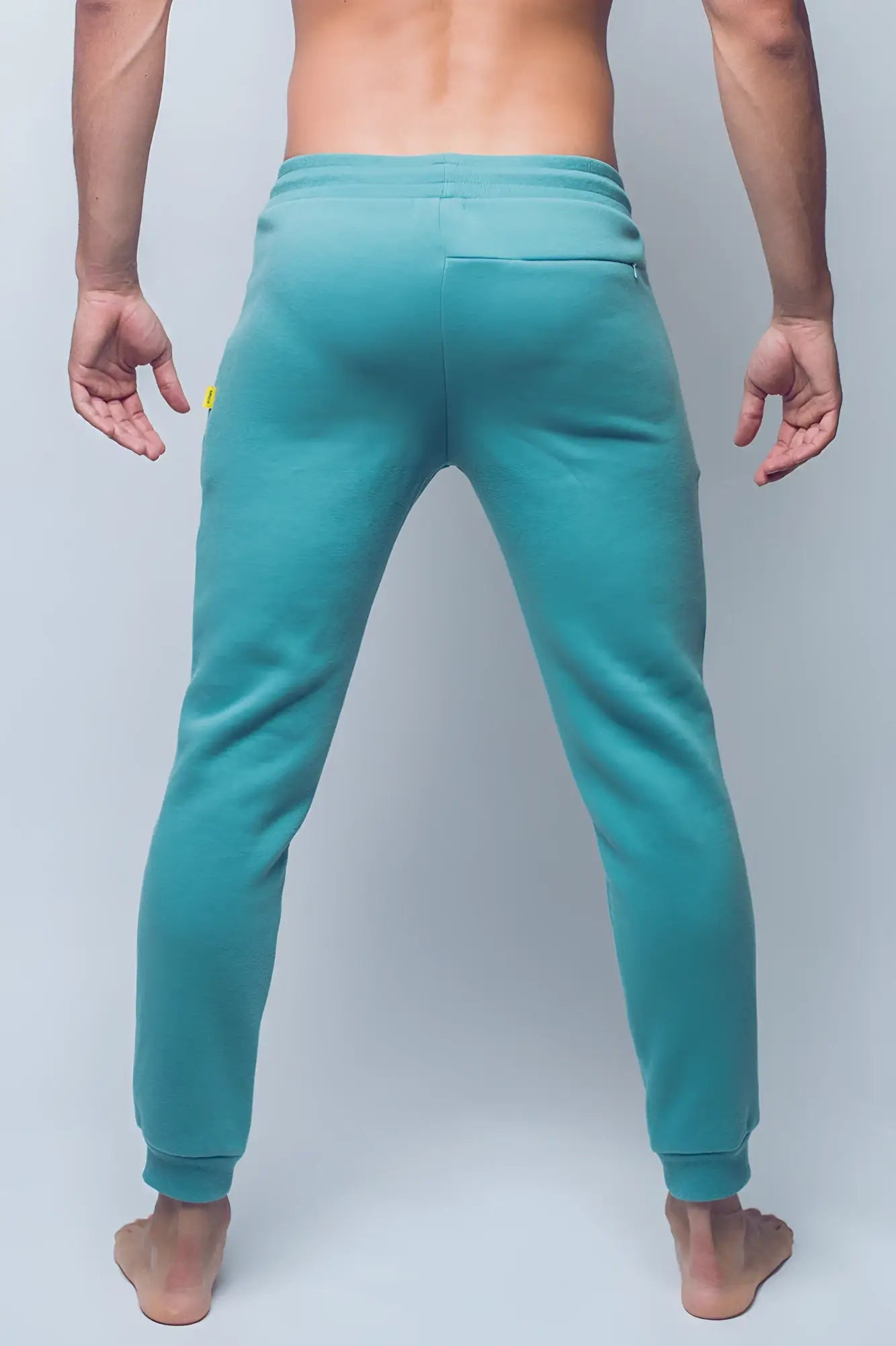Teal SUPAWEAR recovery jogger pants with soft stretchy fabric and subtle yellow branding on the side seam