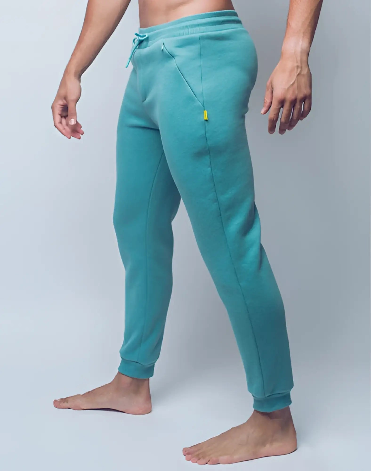 Teal supawear recovery pants with drawstring waistband and yellow zipper pull on side pocket in reboot green