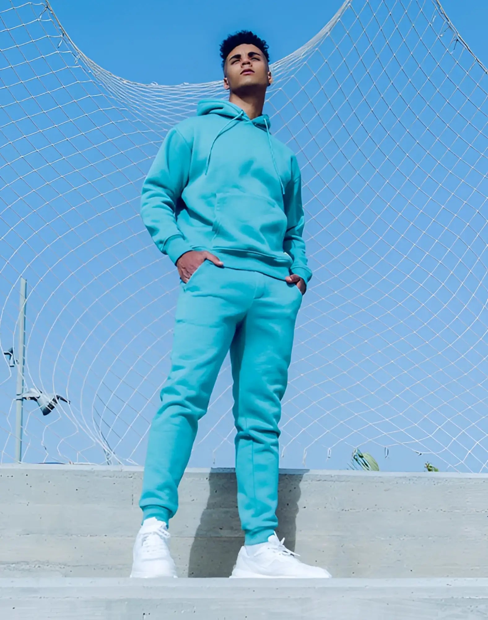 A vibrant turquoise fleece supawear recovery pants and hoodie set with a relaxed fit for comfortable wear