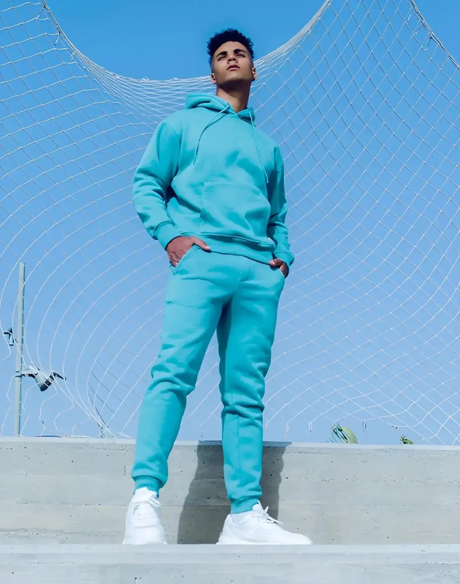 A vibrant turquoise fleece supawear recovery pants and hoodie set with a relaxed fit for comfortable wear
