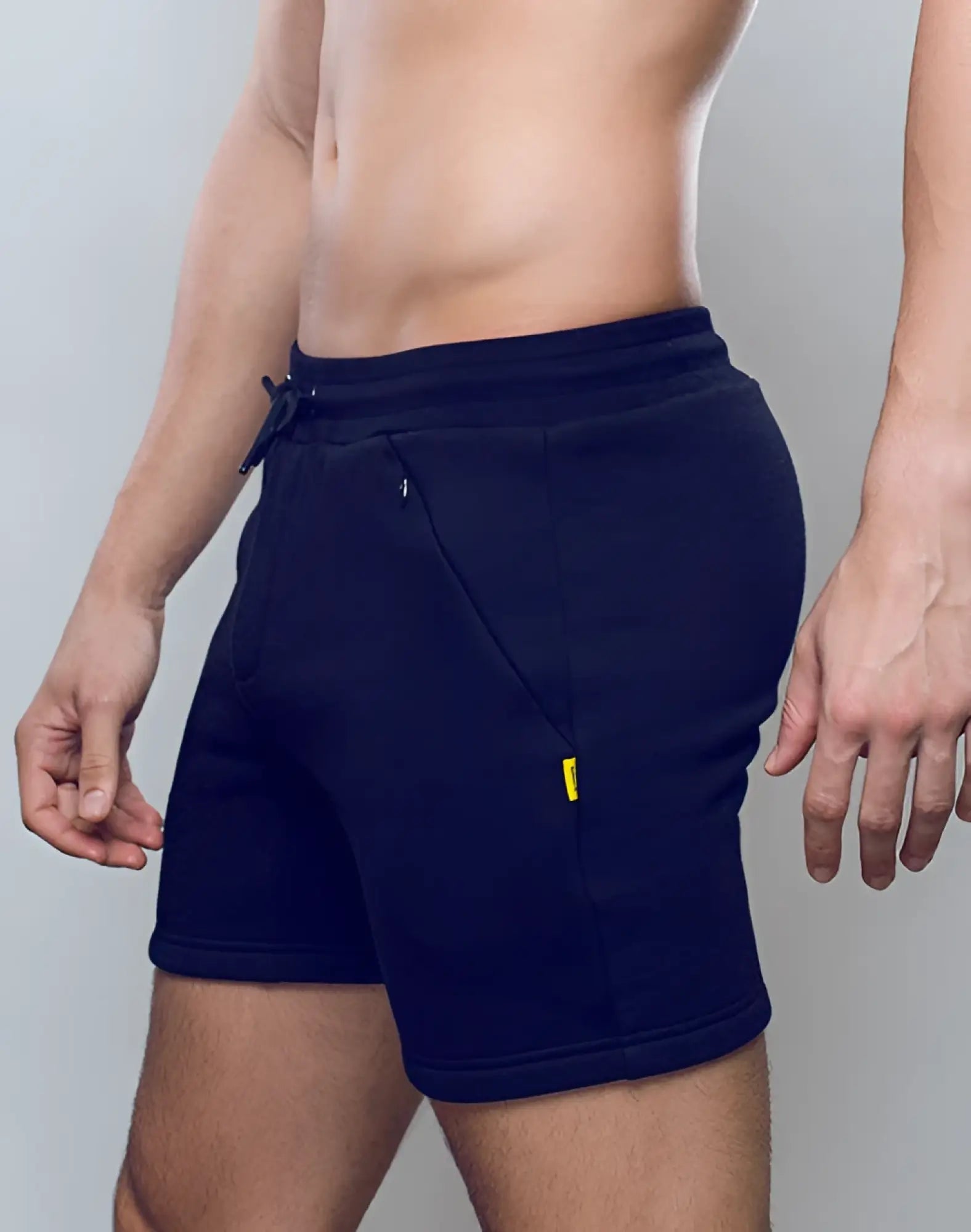 Navy blue supawear recovery fleece shorts with drawstring waistband and yellow tag on side pocket
