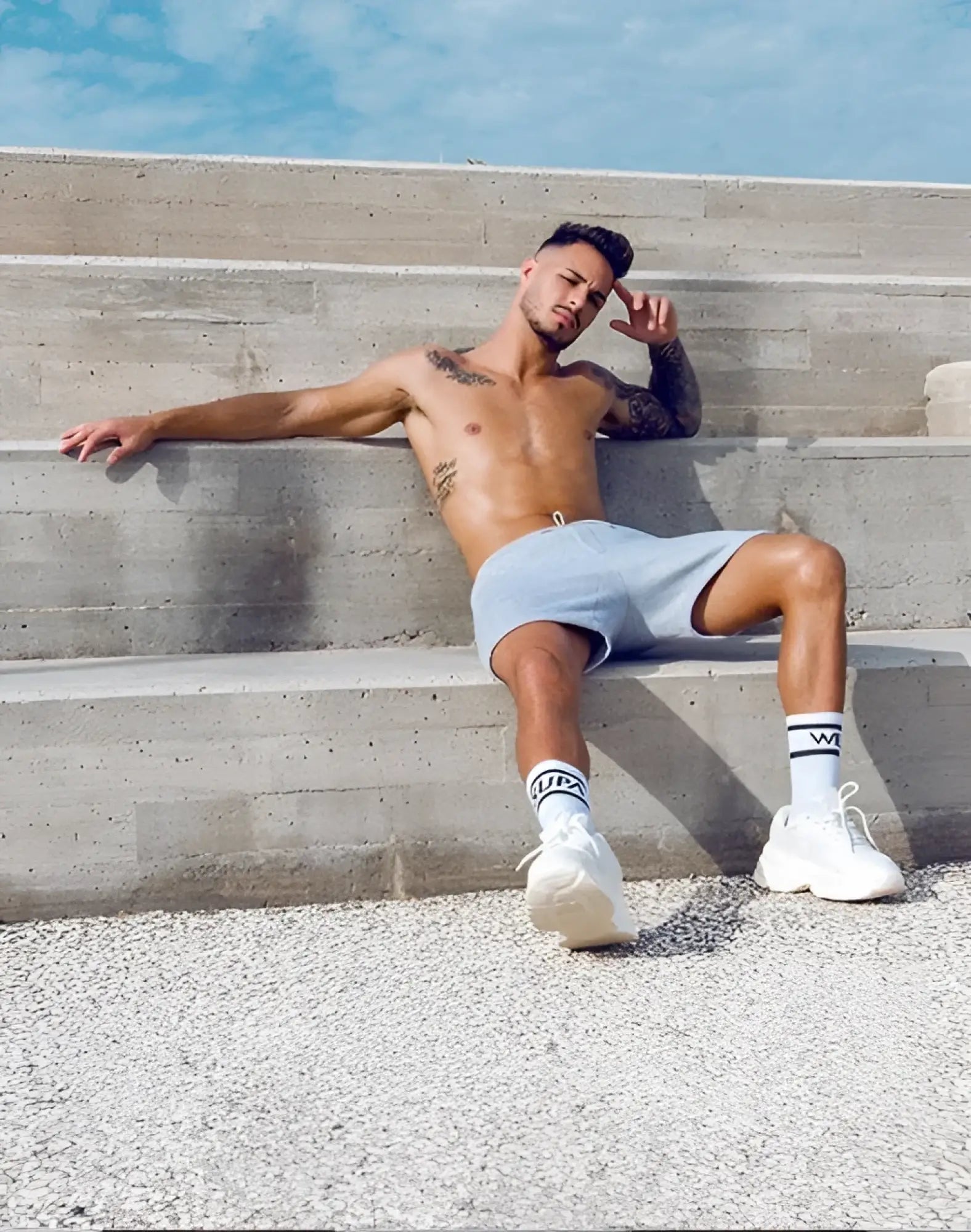 White athletic sneakers with chunky sole and minimalist design paired with SUPAWEAR recovery shorts grey marle