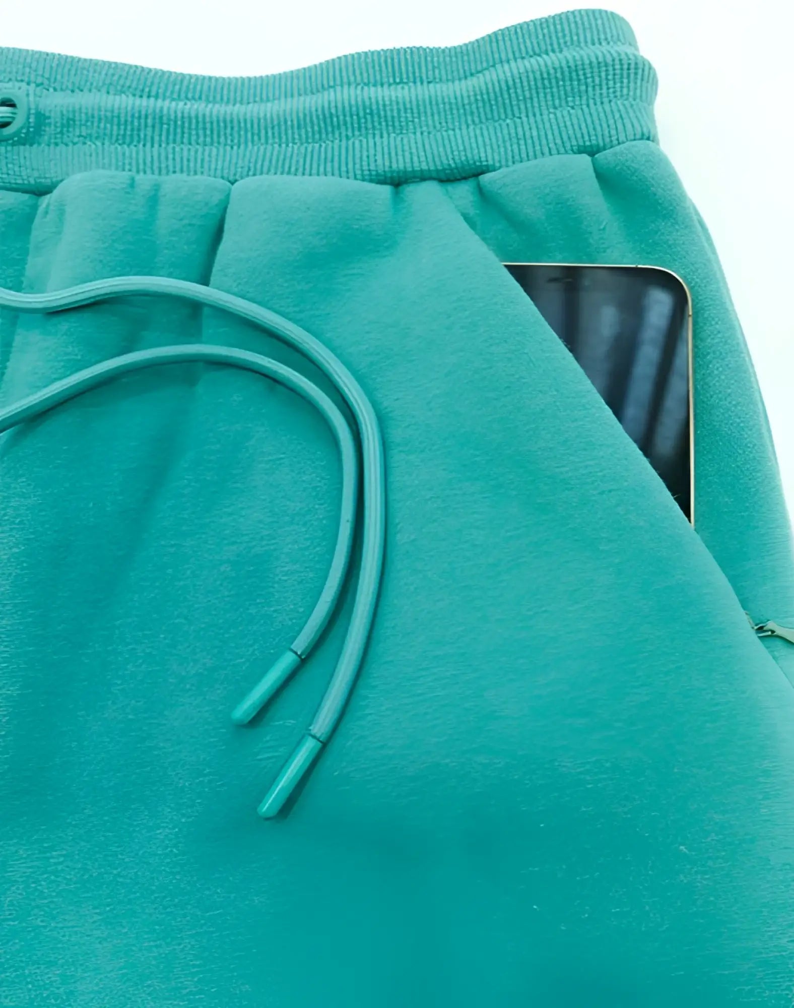 SupaWear recovery shorts in reboot green fleece with matching drawstring waistband and side pocket holding a smartphone