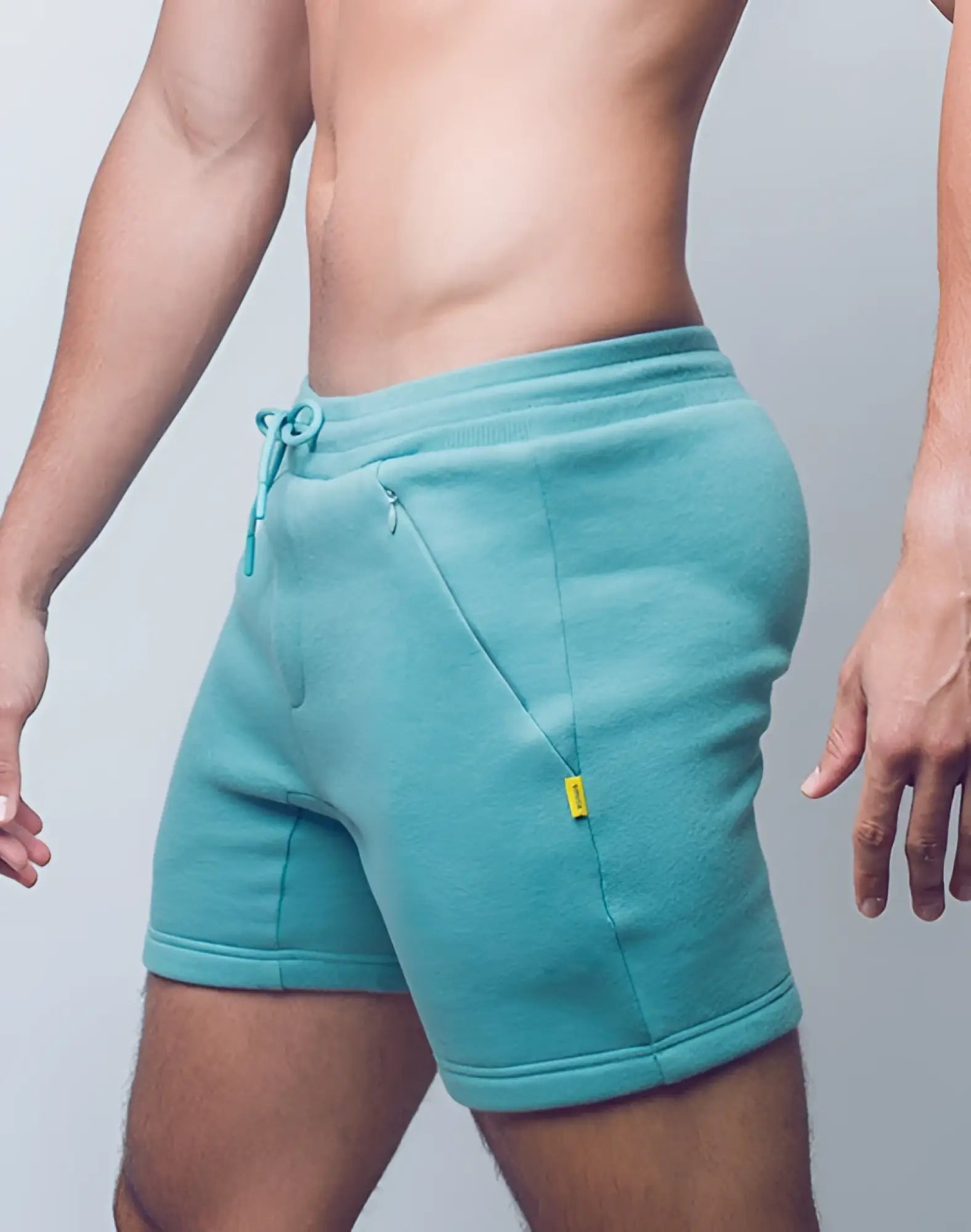 Teal supawear recovery fleece shorts with drawstring waistband and yellow tag on side pocket in reboot green
