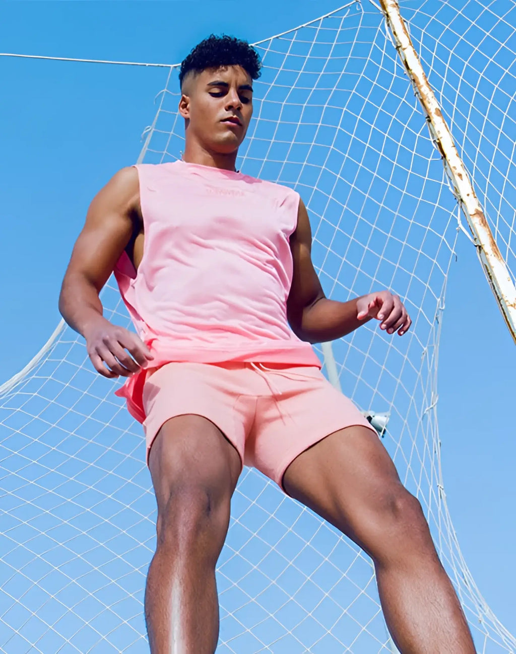 Pink sleeveless SUPAWEAR recovery tank with subtle chest logo designed for athletic performance and comfort