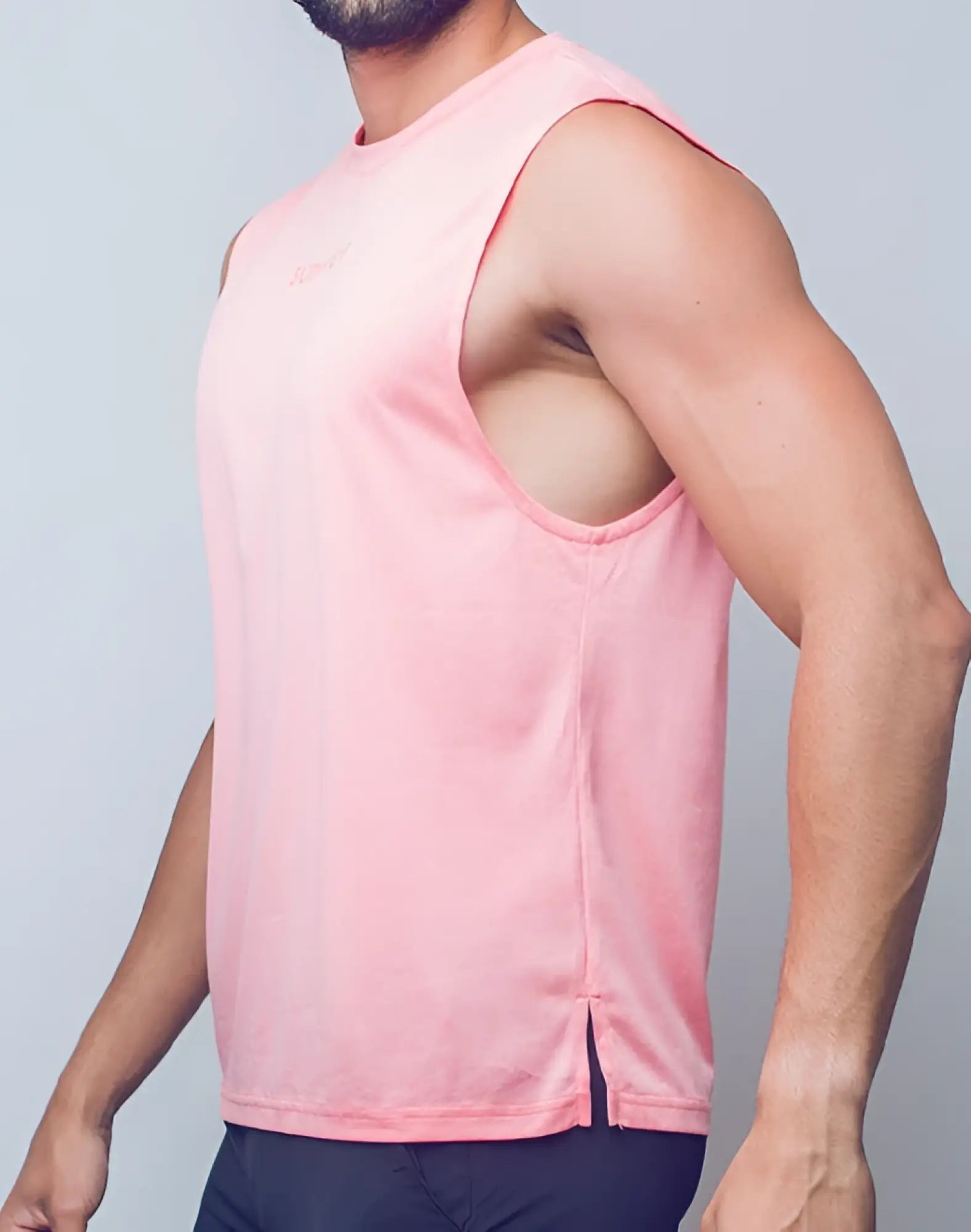A soft pink supawear recovery tank with a subtle logo and side slit in breathable athletic fabric for workout comfort