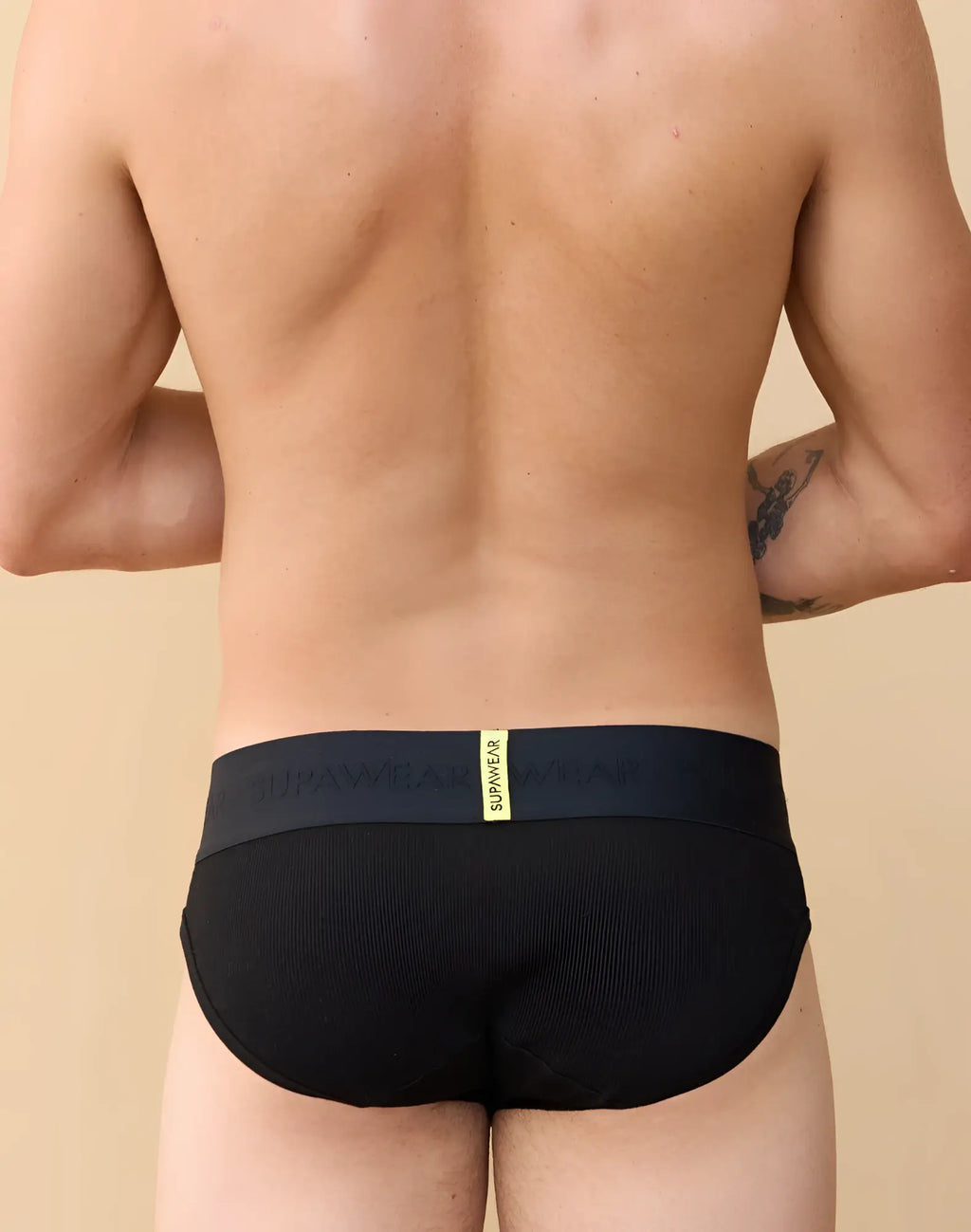 Black supawear ribbed briefs featuring a textured fabric and a contrasting yellow waistband label