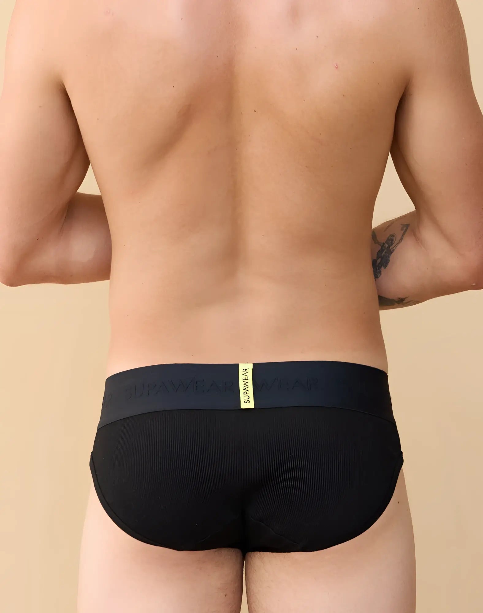 Black supawear ribbed briefs featuring a textured fabric and a contrasting yellow waistband label