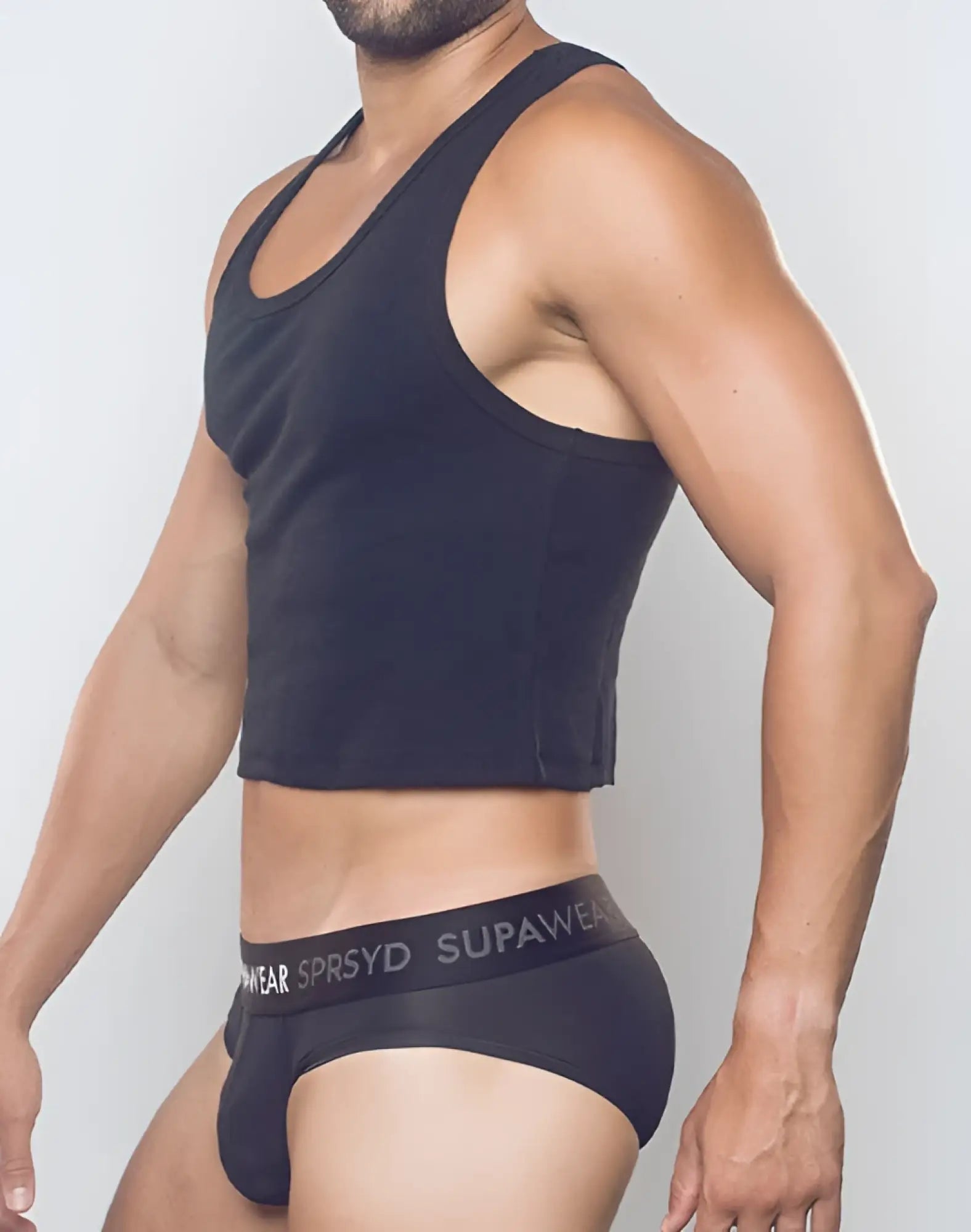 Black ribbed SUPAWEAR cropped singlet with racerback design and curved hemline for casual wear showing back side
