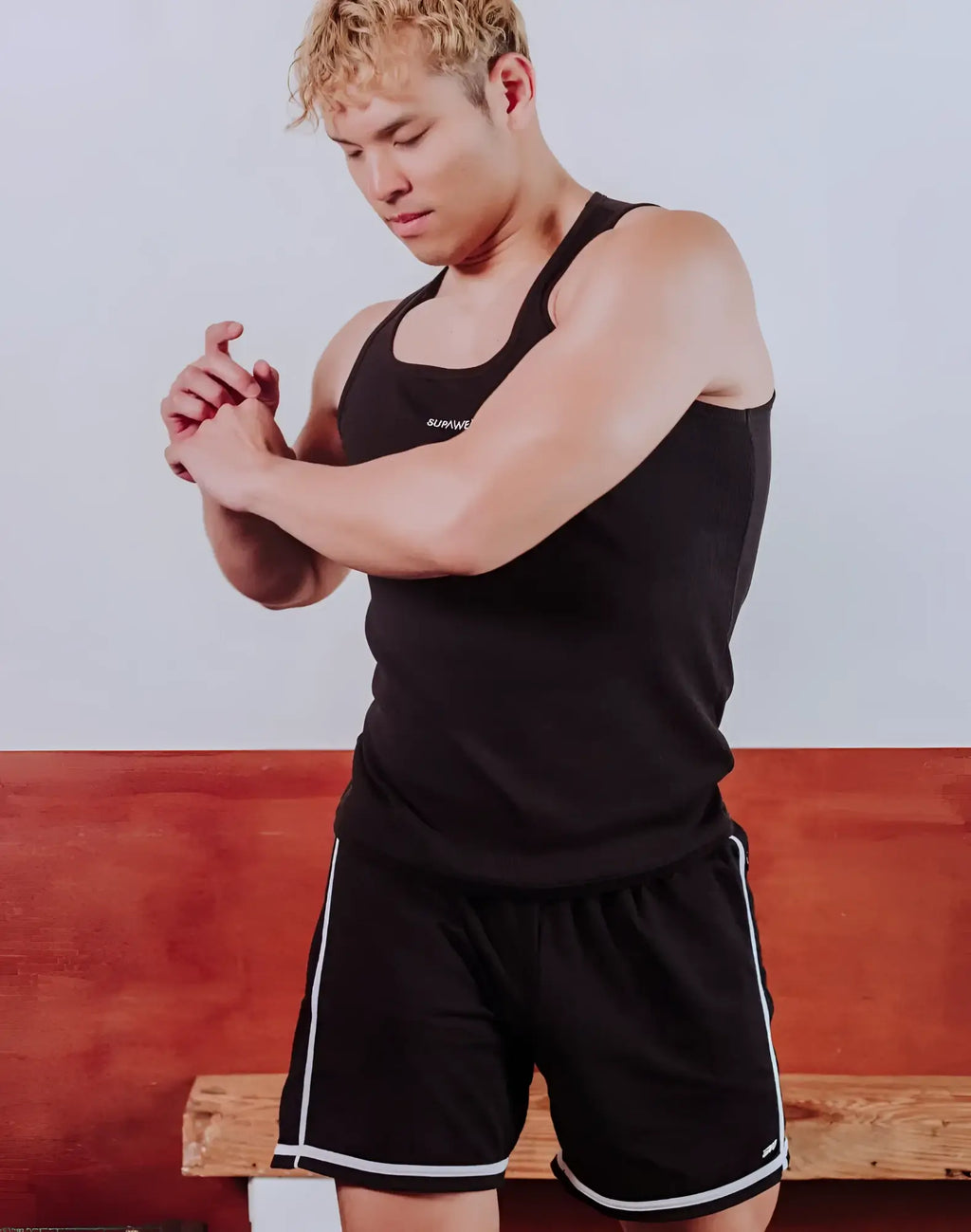 Black SUPAWEAR semi-squared singlet with white trim and small chest logo designed for athletic performance