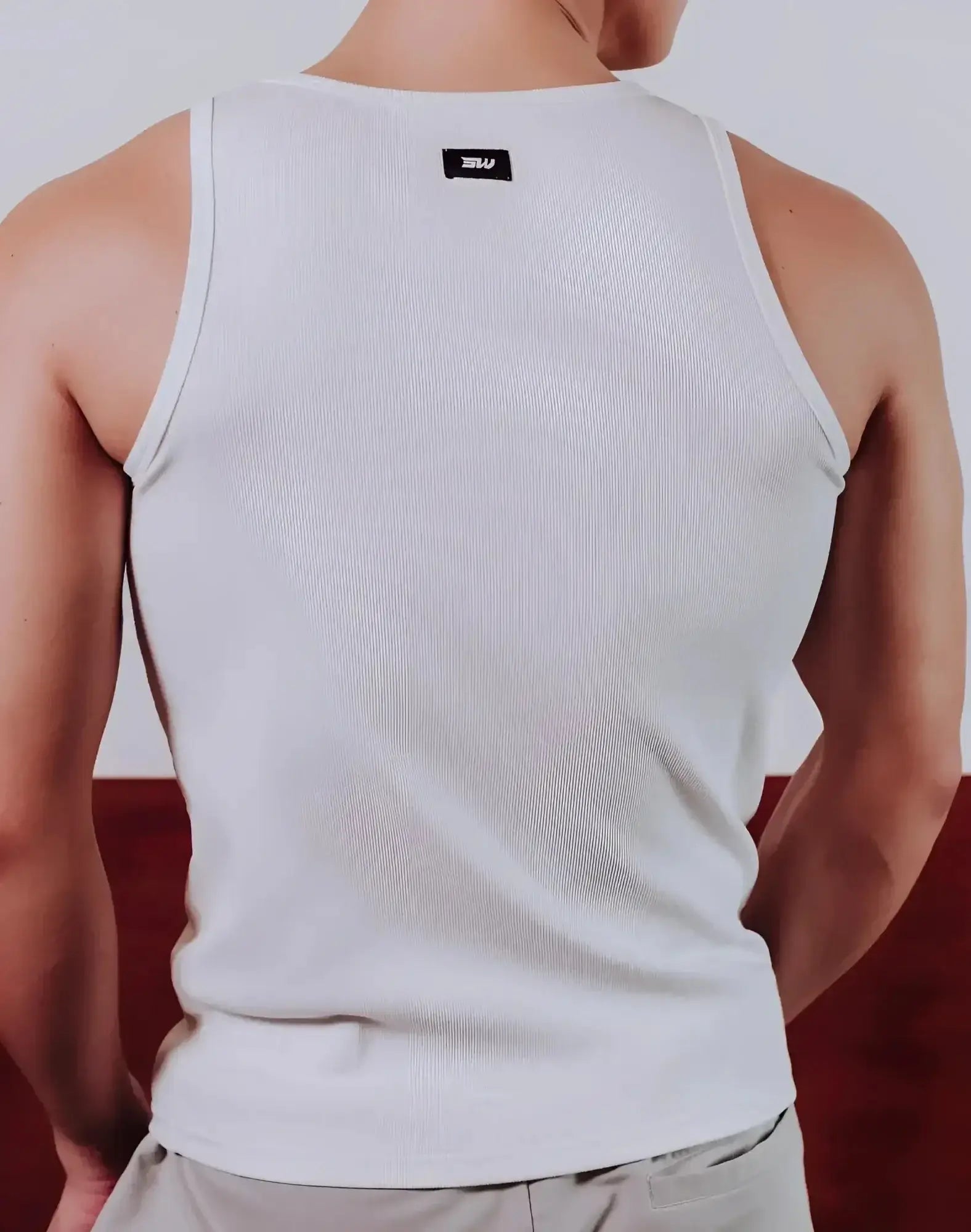 White ribbed cotton tank top with small black supawear brand tag at neckline semi squared singlet design