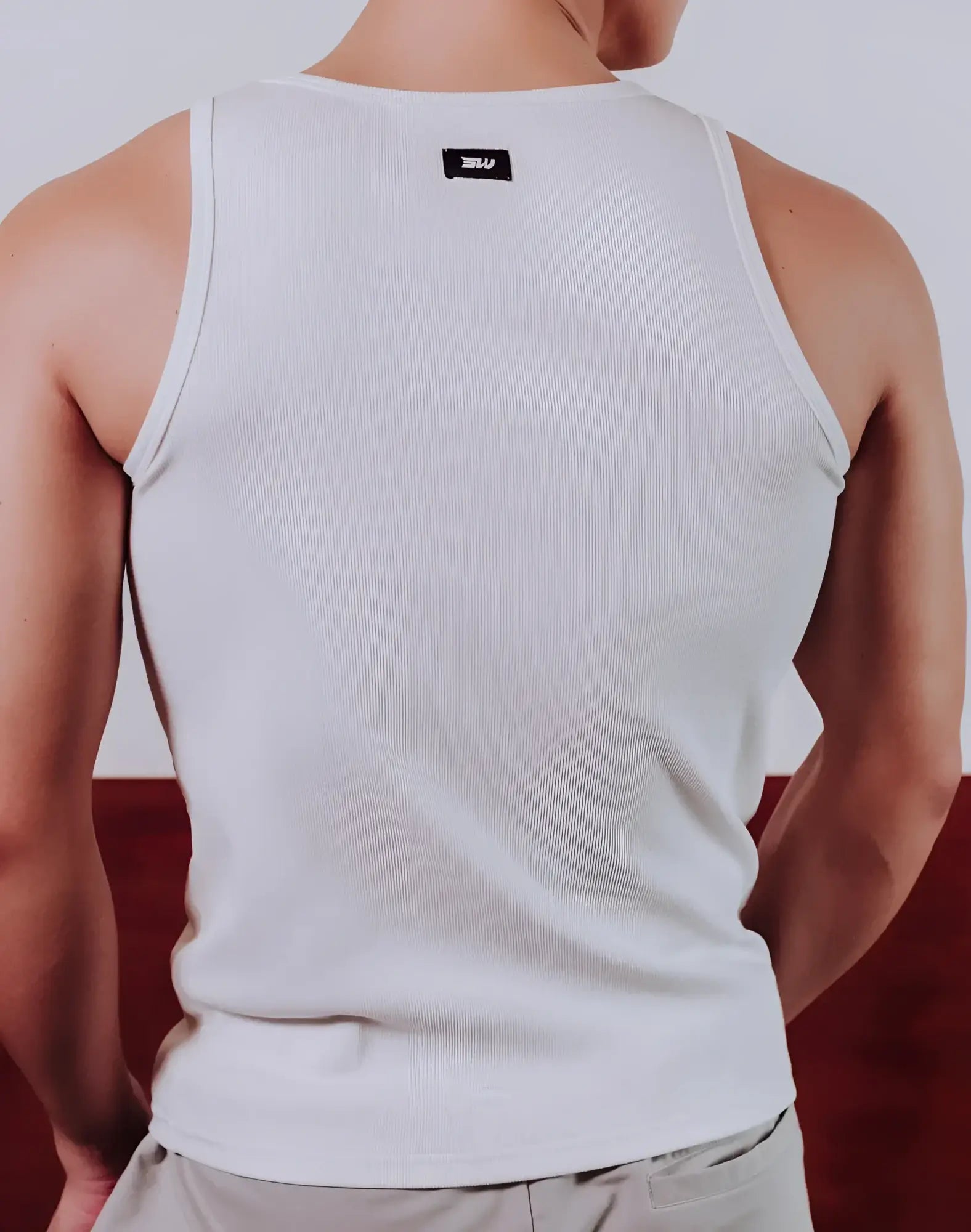 White ribbed cotton tank top with small black supawear brand tag at neckline semi squared singlet design