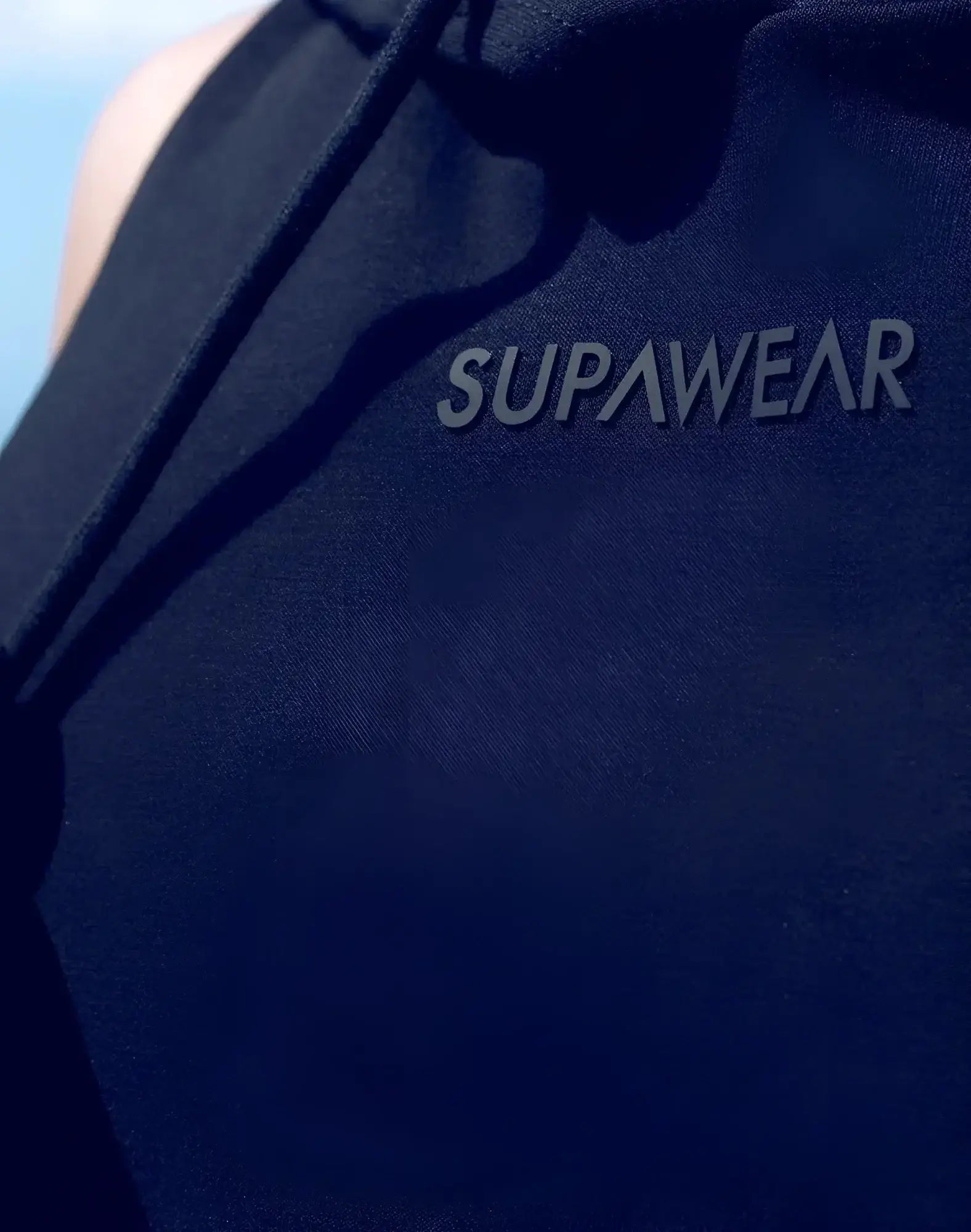 SupaWear sleeveless hoodie in dark navy blue with a subtle raised gray logo embroidered across the chest