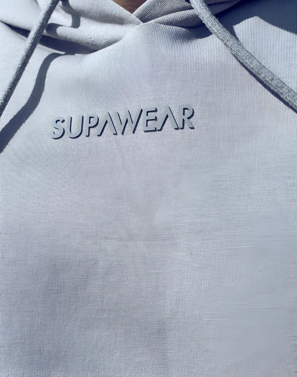 Light gray supawear sleeveless hoodie with subtle textured fabric and matching drawstrings for casual wear