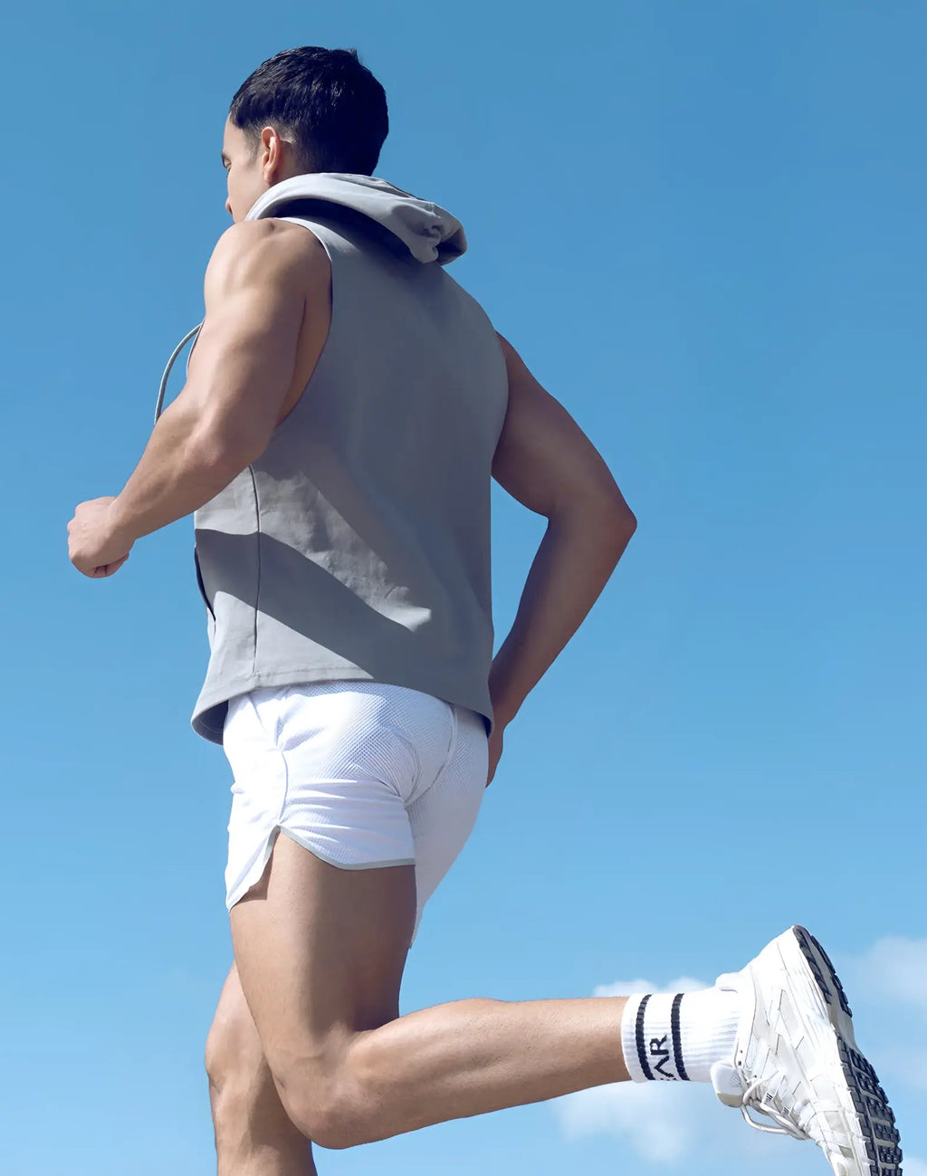 White athletic shorts with subtle textured pattern and side pockets paired with supawear grey sleeveless hoodie