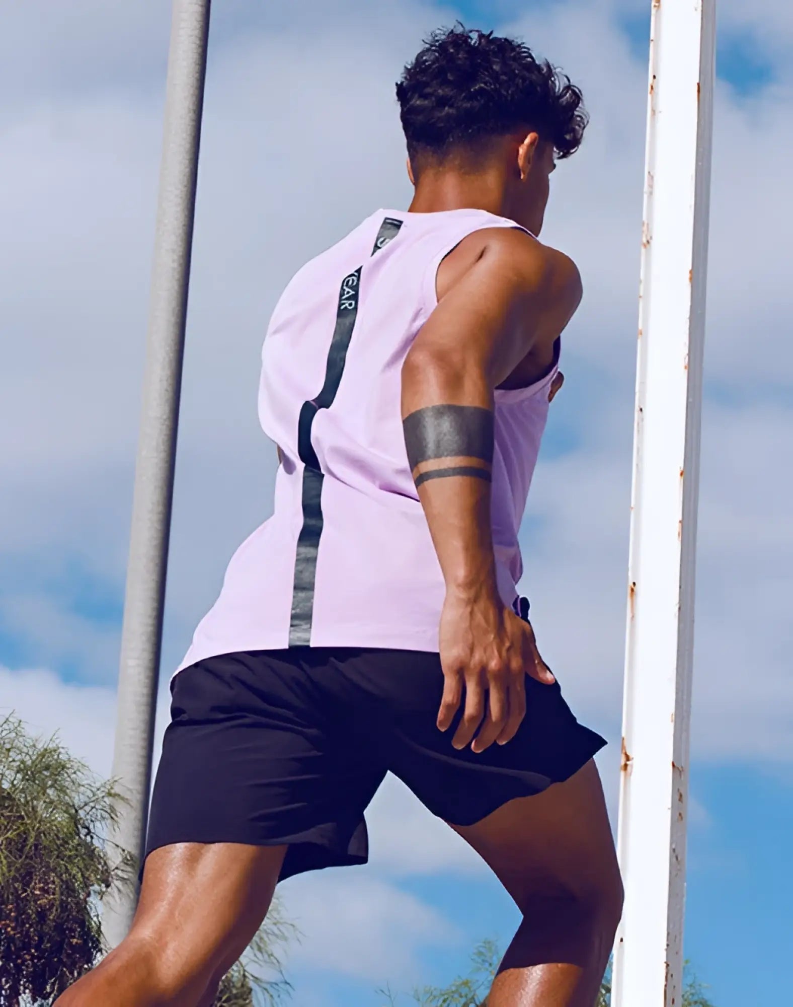 Back view of supawear solid and mesh tanktop purple heather with black vertical stripe and small logo on strap